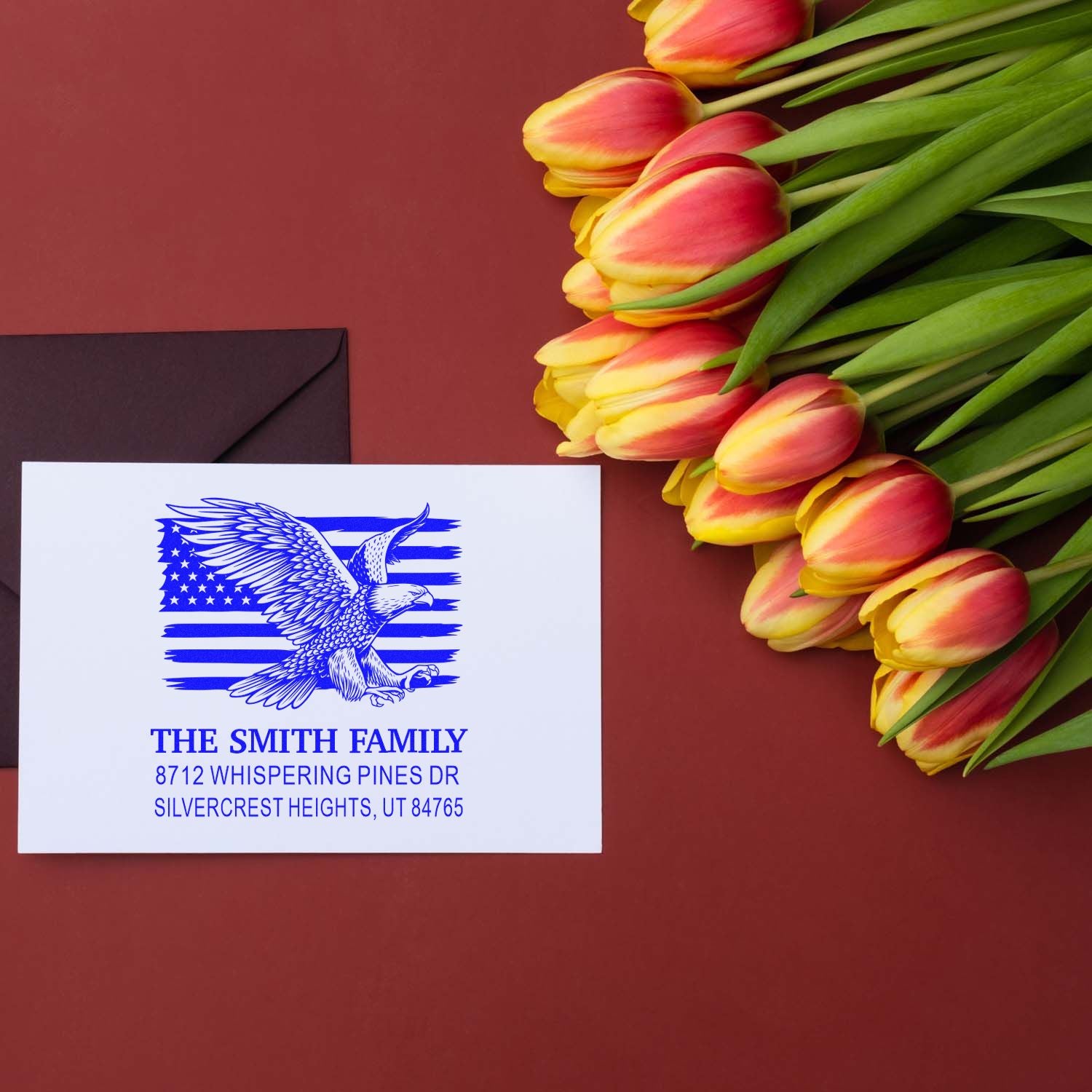 Personalized rubber address stamp with eagle and American flag design for The Smith Family, featuring name and full address in blue ink on envelopes.