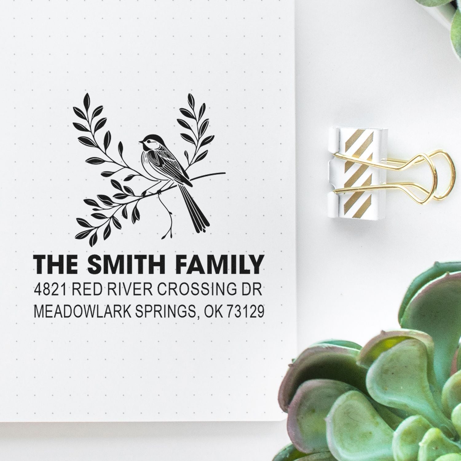 Personalized return address rubber stamp with bird and botanical branch design, family name, street address, and city, state, ZIP.