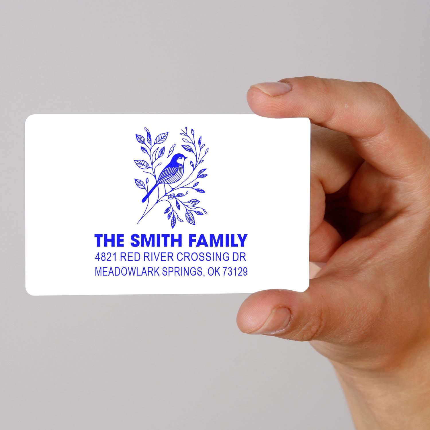 Custom rubber return address stamp with blue bird and floral design, The Smith Family name, and Meadowlark Springs, OK mailing address.