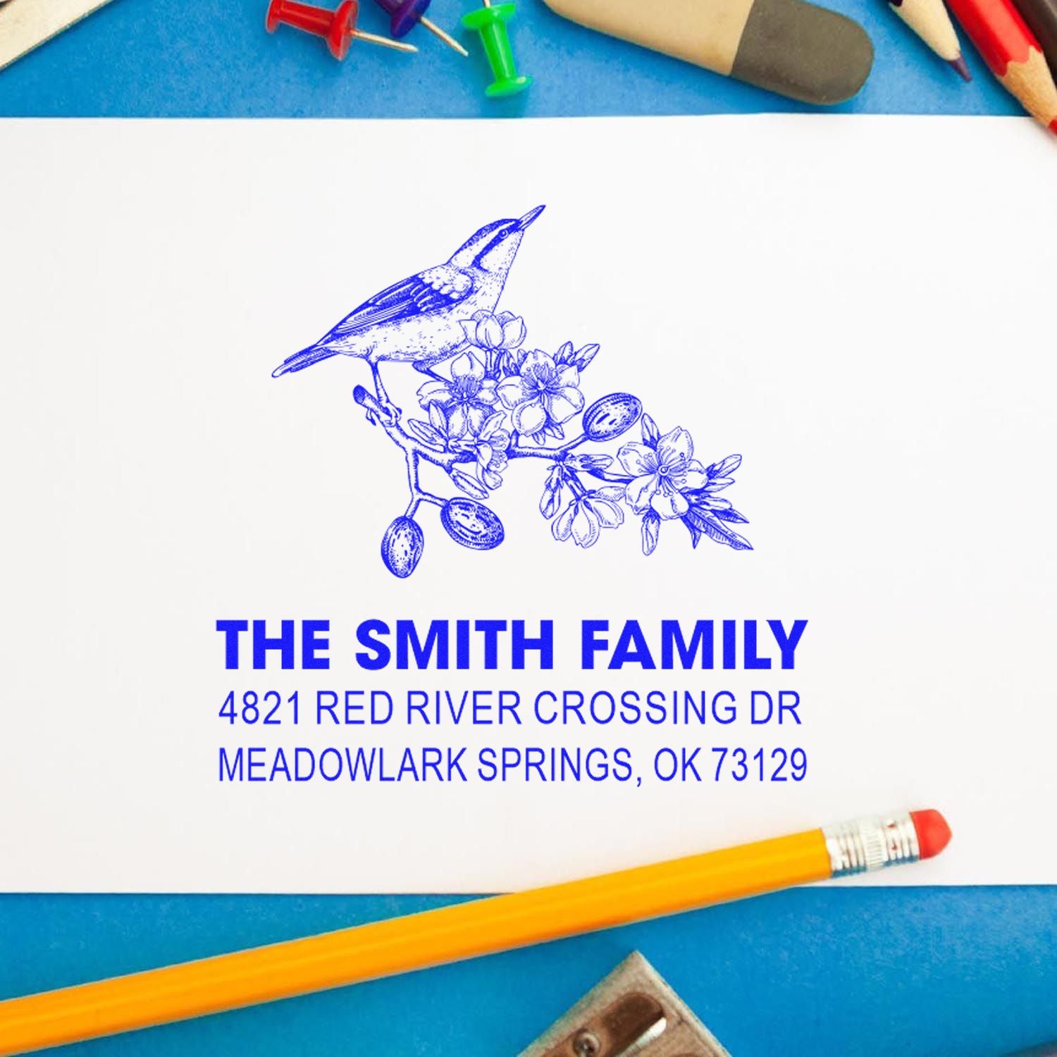 Custom family address rubber stamp with bird and floral design, personalized return address stamp in blue ink on white paper for mailing and crafts