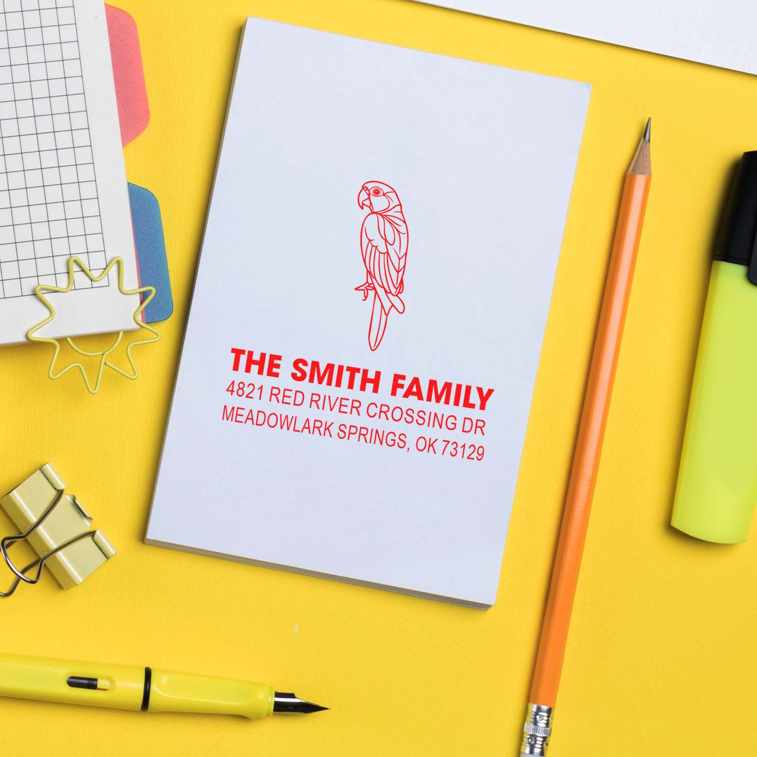 Custom address rubber stamp with parrot design and Smith family return address on notebook, ideal for personalized mailing and stationery branding.