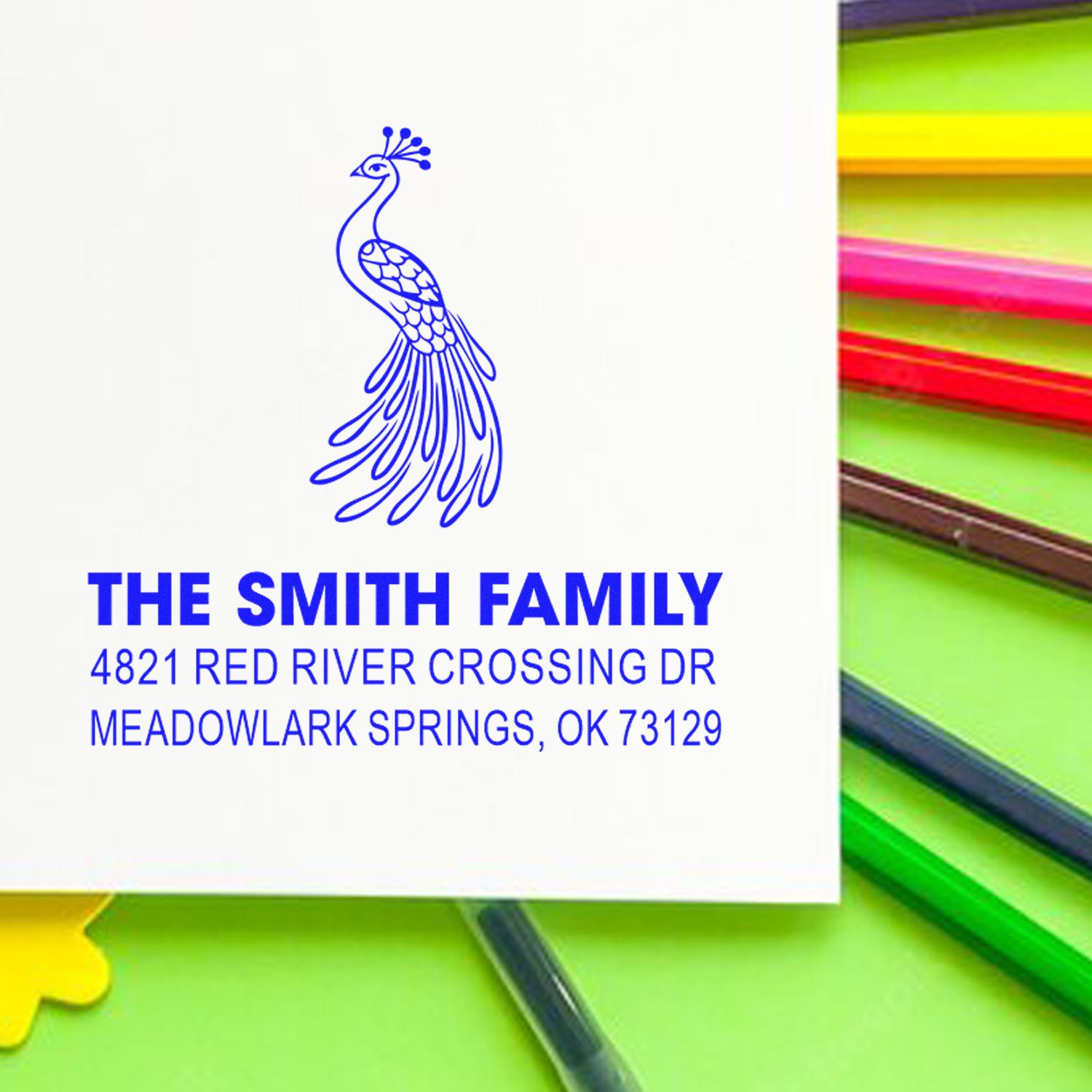 Custom peacock address rubber stamp with The Smith Family name, street address, and city state ZIP in blue ink for personalized stationery and mail.