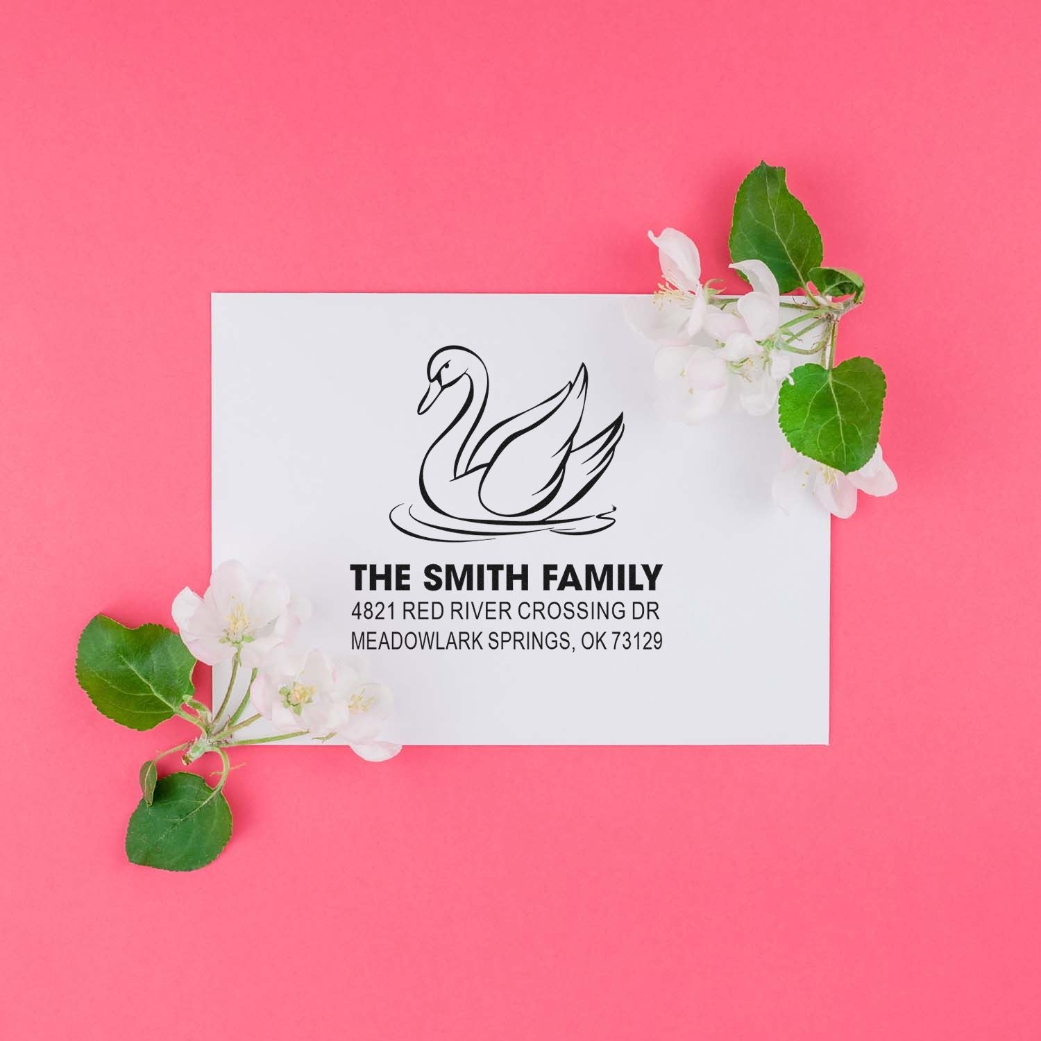 Custom return address rubber stamp with swan design, The Smith Family name, and Meadowlark Springs, OK address on a white card with pink florals.