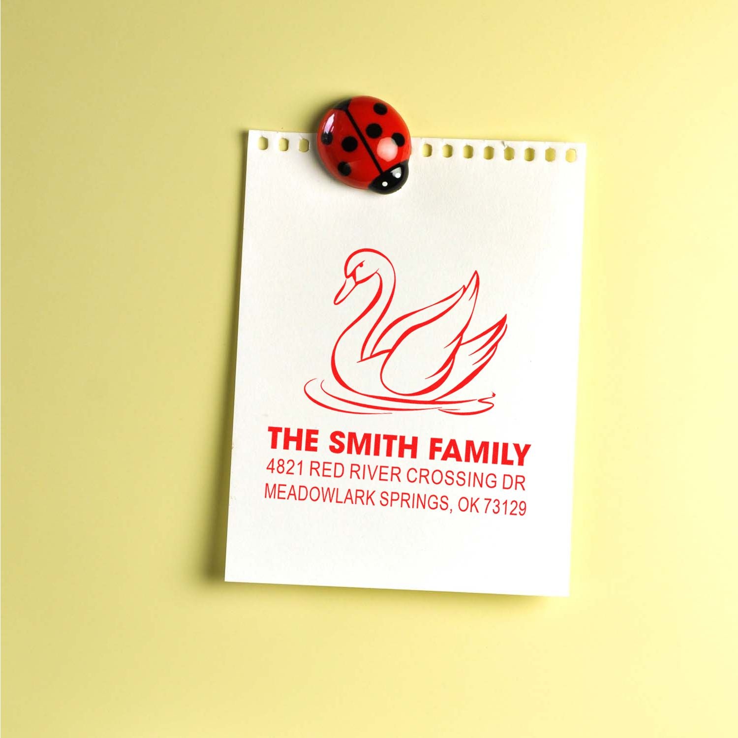 Custom rubber address stamp with swan design, featuring The Smith Family name and mailing address in red ink on a note card