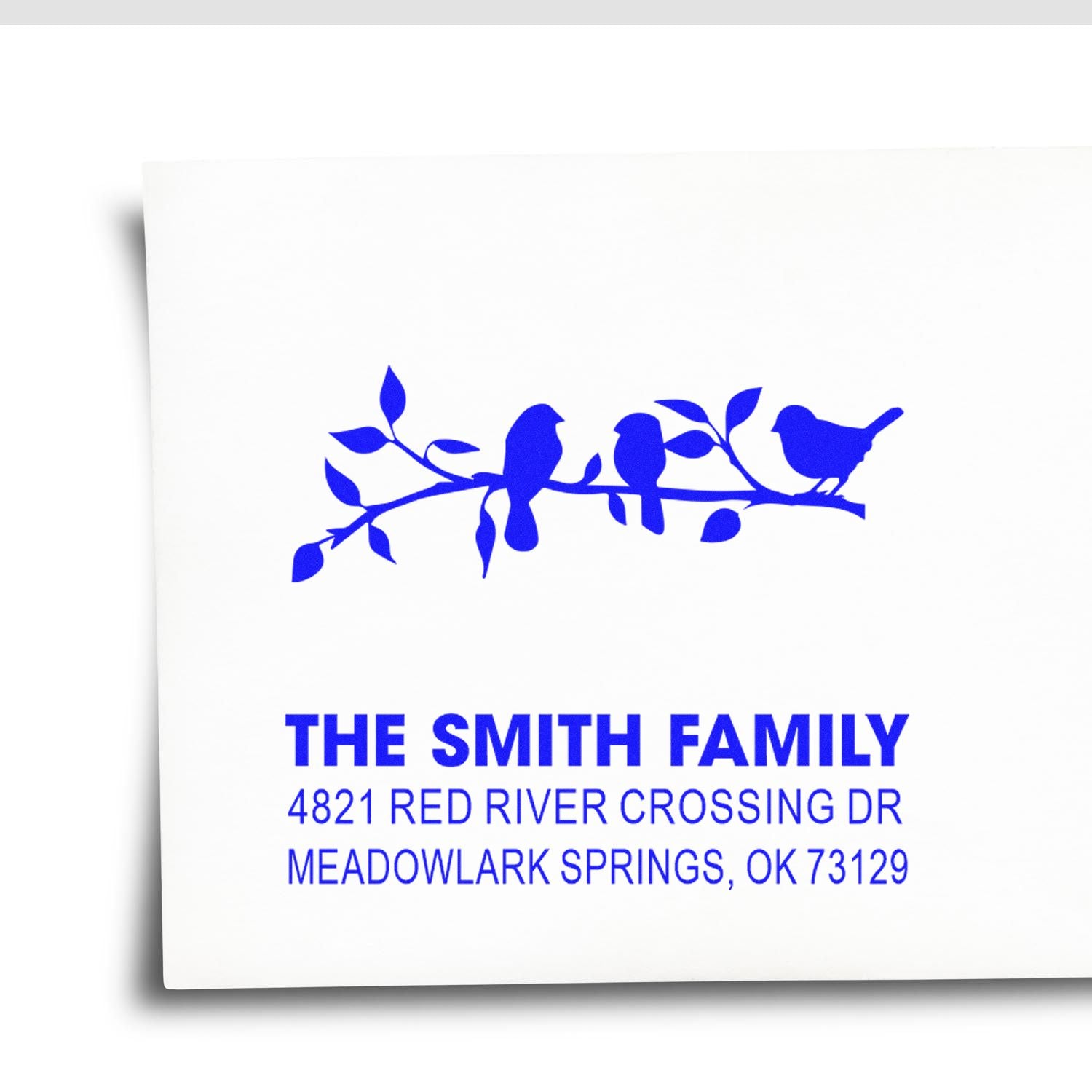 Custom self-inking address rubber stamp with blue bird branch design, The Smith Family name, and full mailing address for envelopes and mailings.