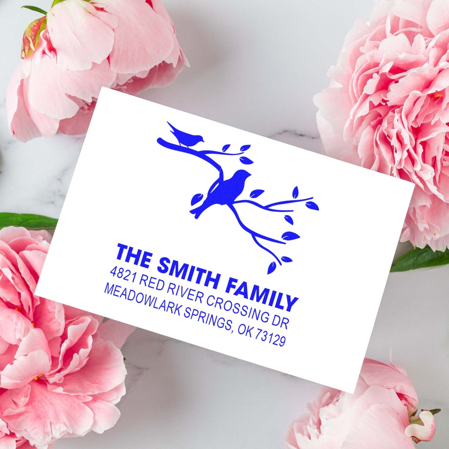 Custom rubber address stamp with blue bird on branch design and Smith family name, street address, and city for personalized mailing use