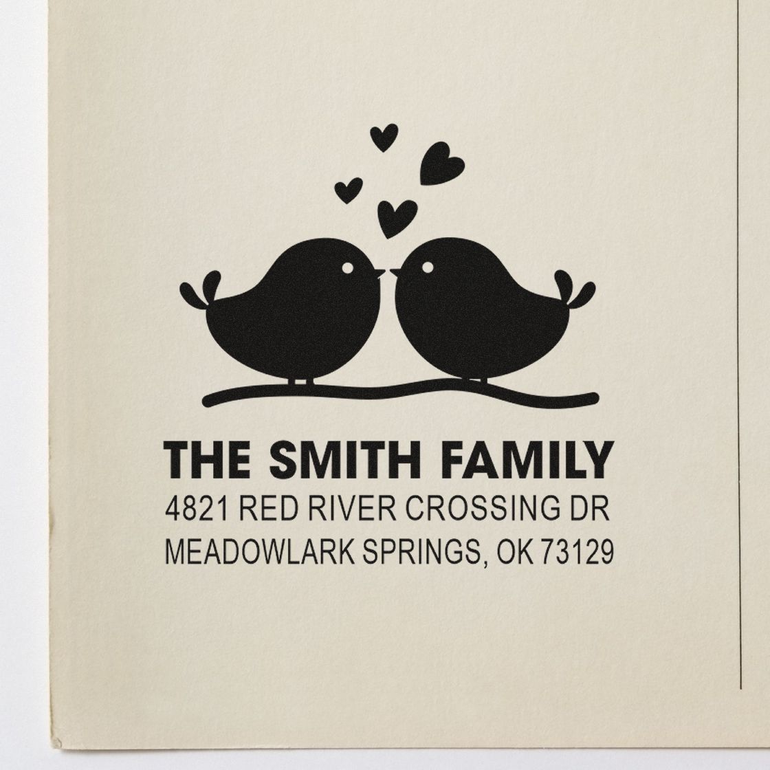 Custom return address rubber stamp with two lovebirds, hearts, and personalized family name and address for wedding stationery and mailings.