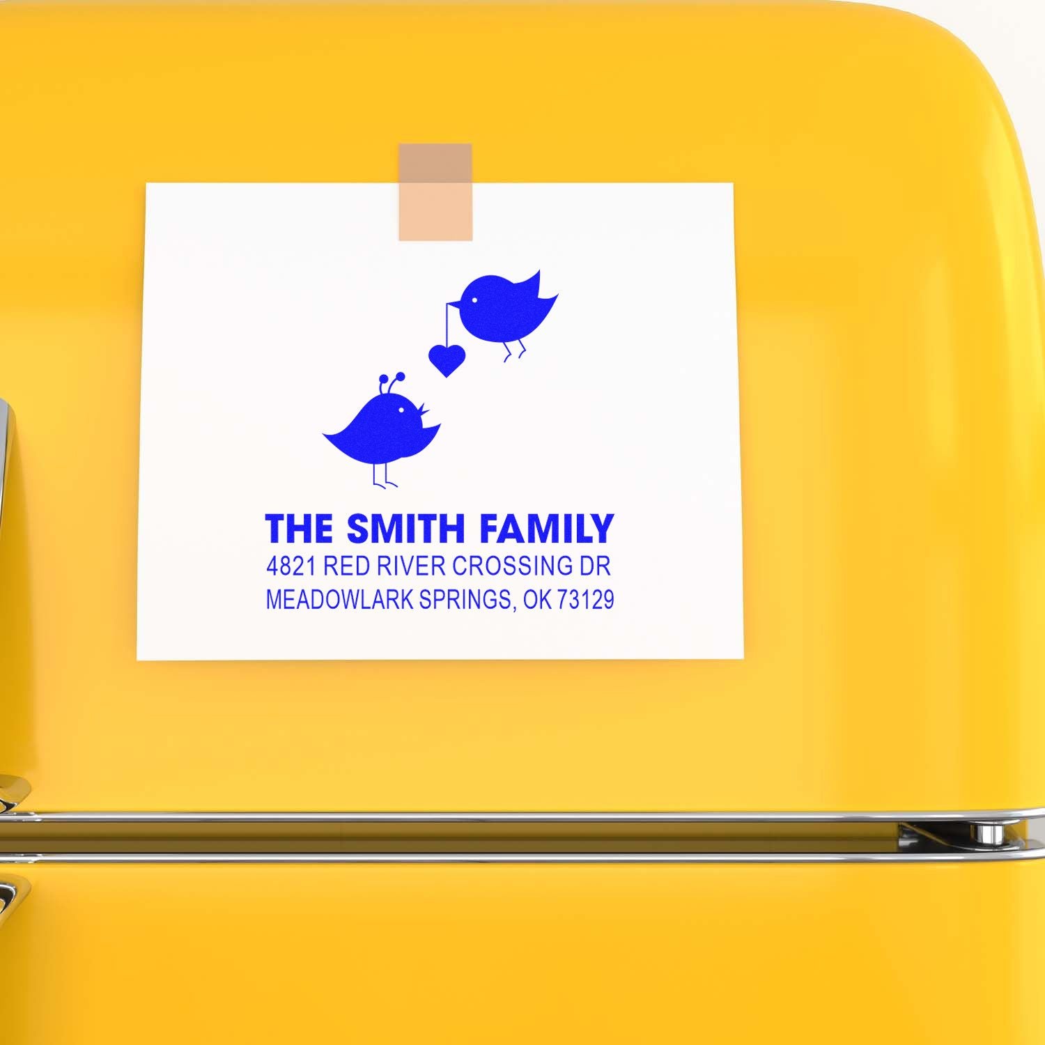 Custom family return address rubber stamp with blue bird design, The Smith Family, and Meadowlark Springs, OK address on yellow background.