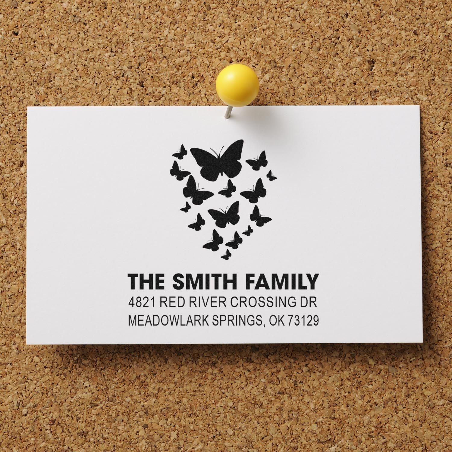 Personalized butterfly family return address rubber stamp featuring black butterflies, custom name, and address on a white card pinned to corkboard.