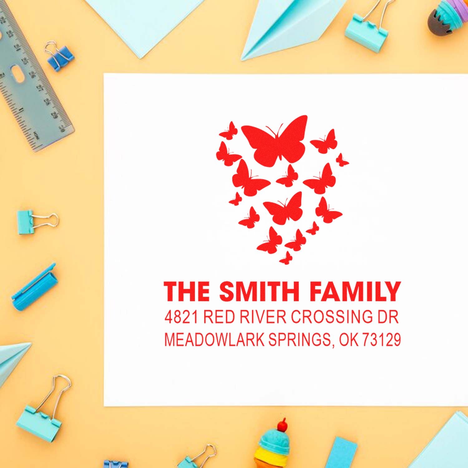 Custom butterfly return address rubber stamp for The Smith Family with name, street, and city printed in red ink for mailing and crafts.
