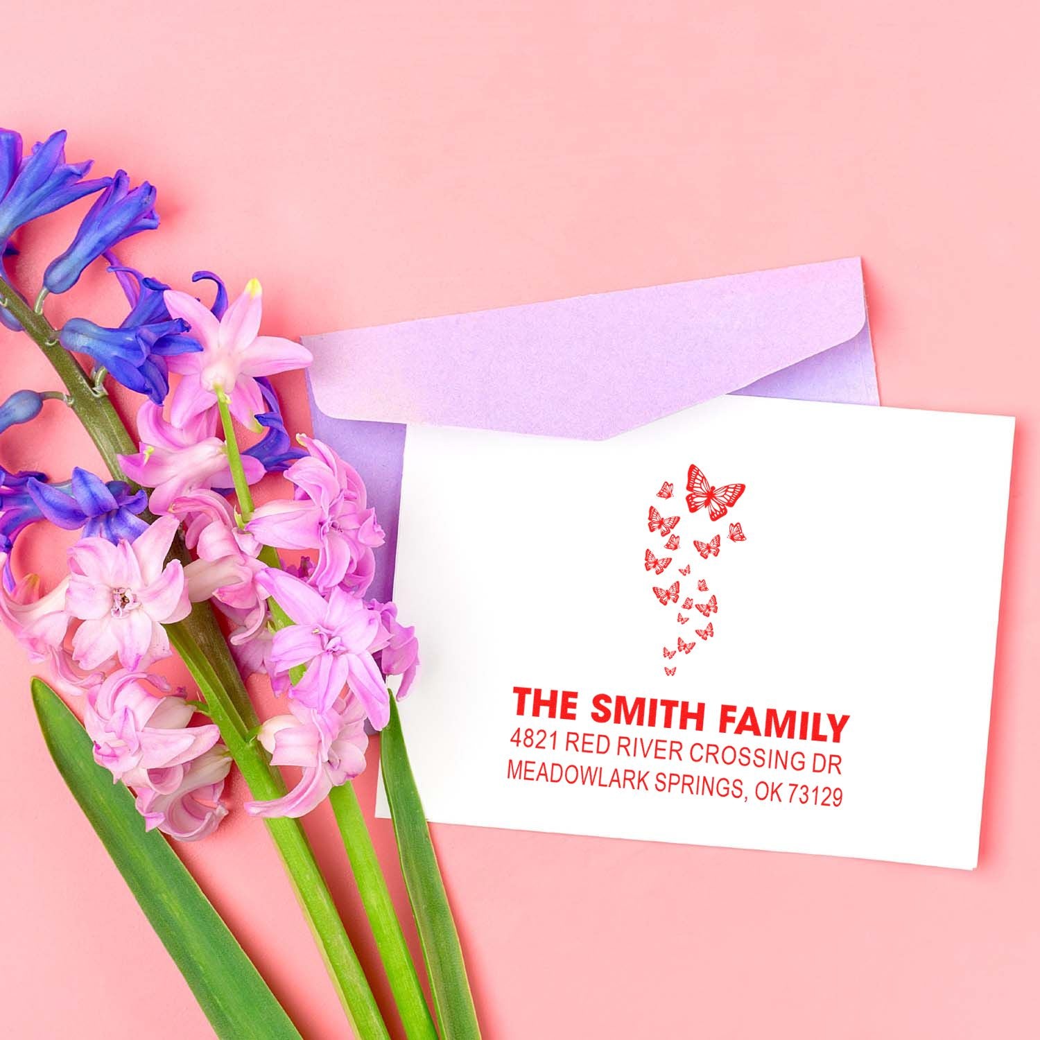 Custom butterfly return address rubber stamp on white card with purple envelope and hyacinth flowers, personalized family mailing stamp design