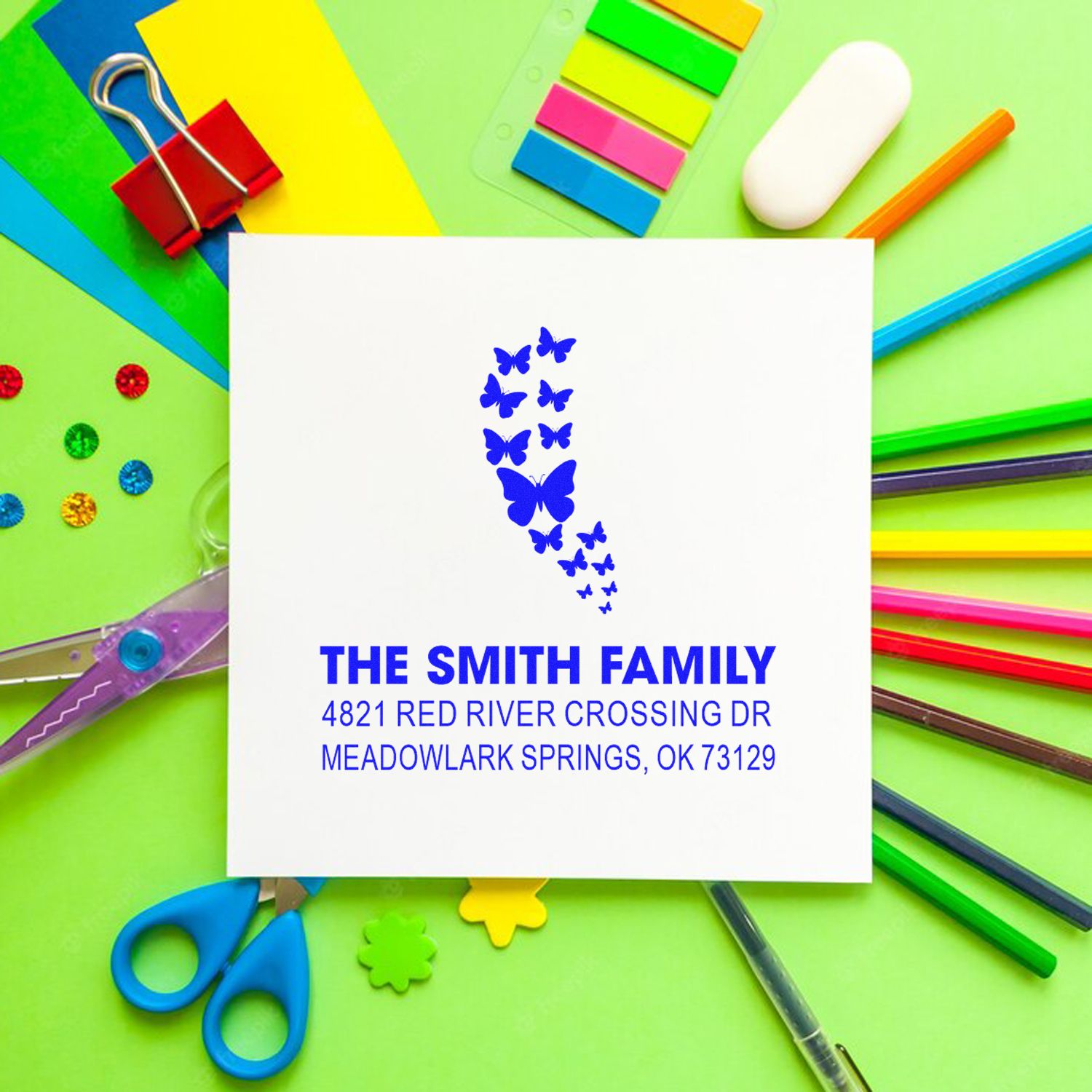 Custom butterfly return address rubber stamp for The Smith Family, featuring blue butterflies and a personalized mailing address on a white card.