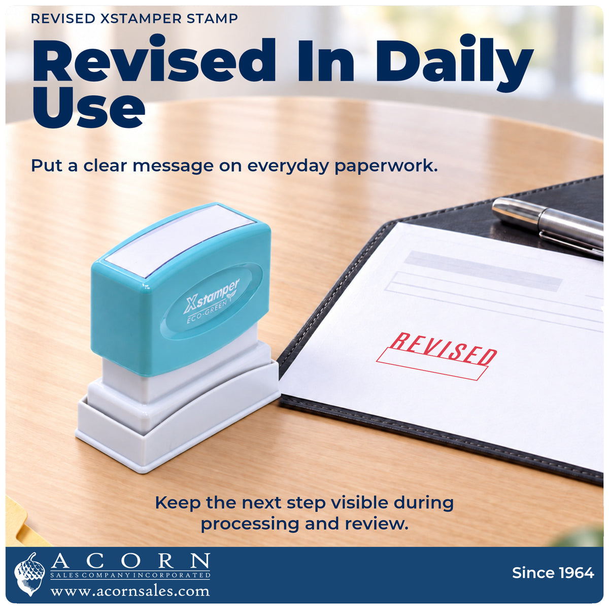 Xstamper Revised Stamp being pressed to leave an imprint reading "Revised"