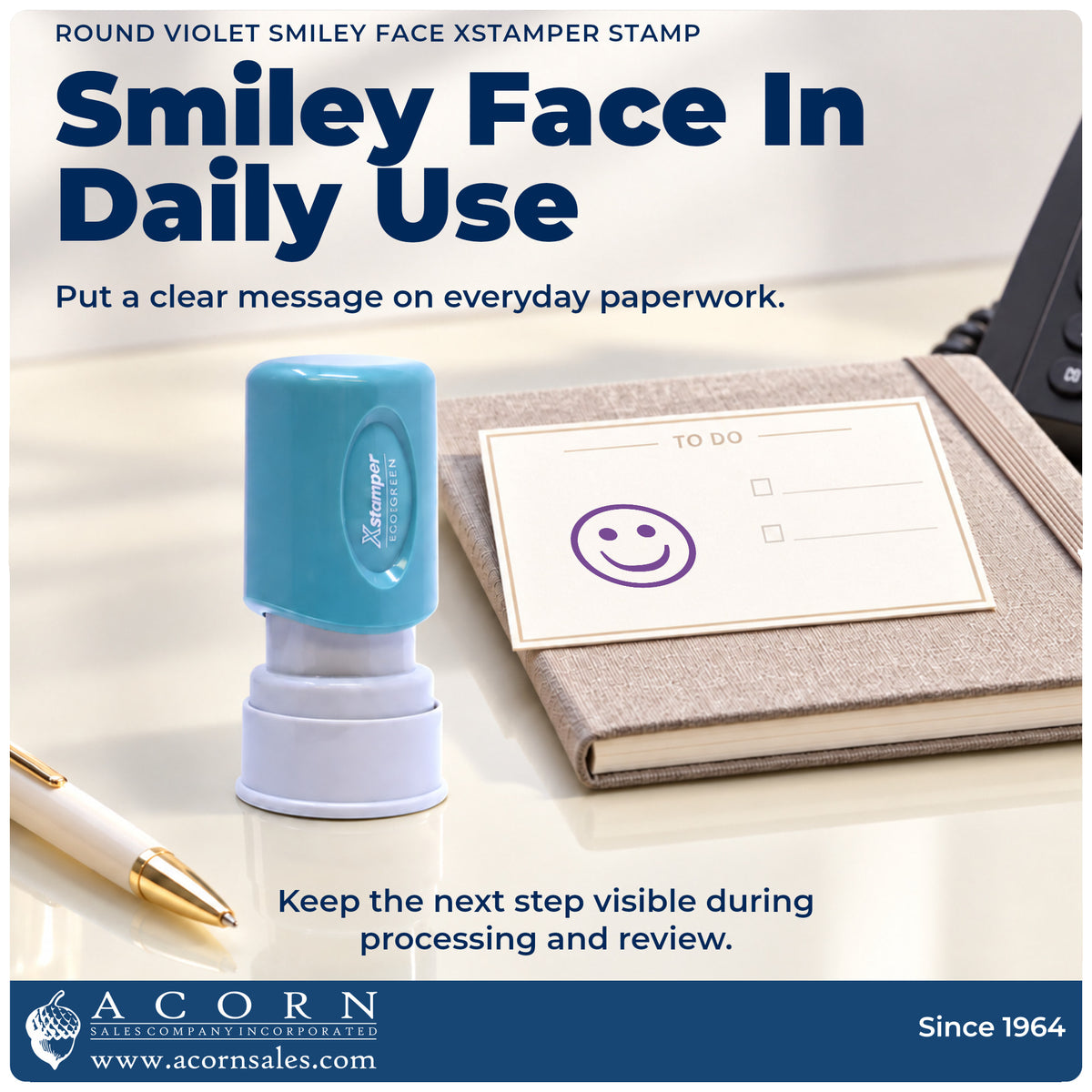Xstamper Smiley Face Stamp – Round Violet Pre-Inked being pressed to leave an imprint reading "Smiley face"