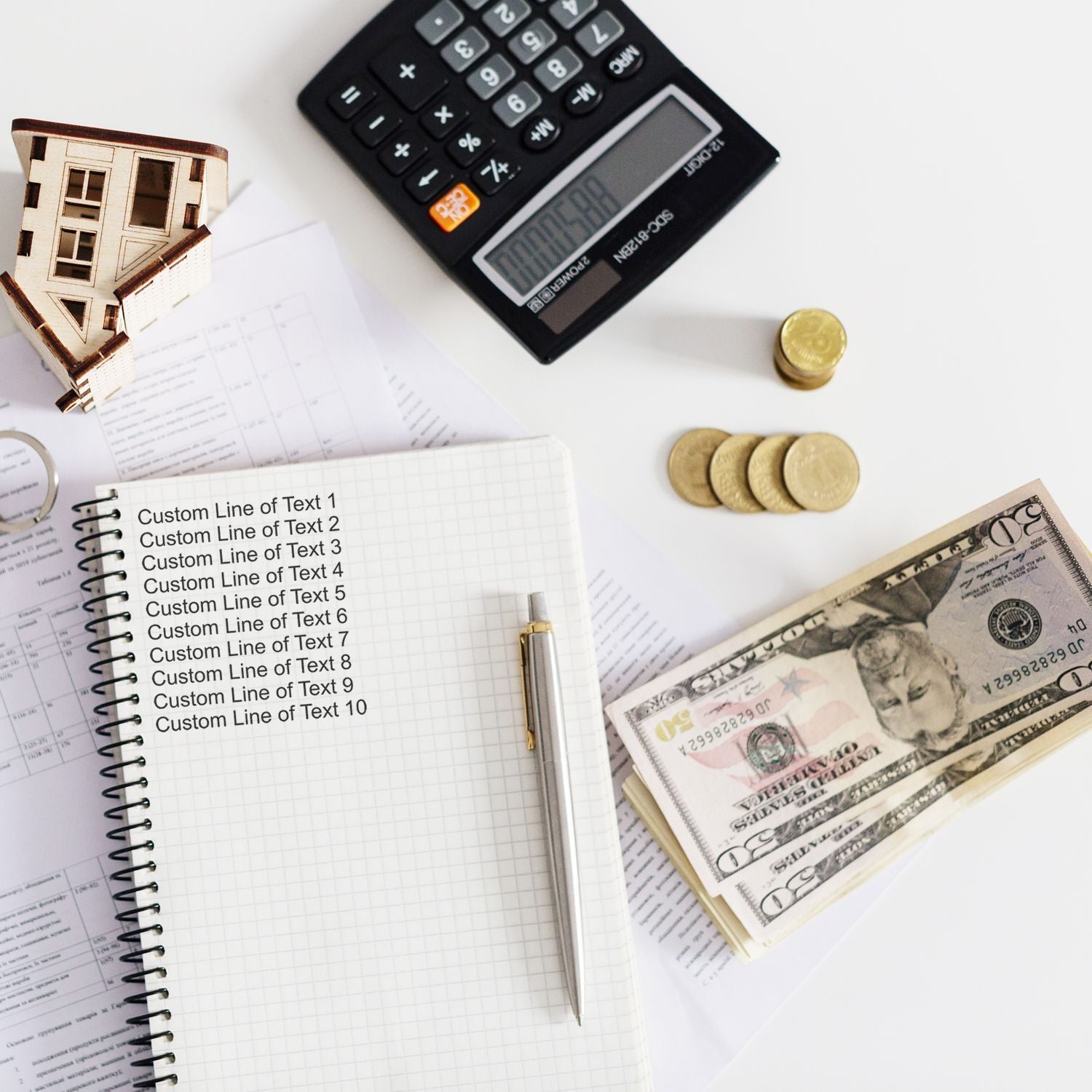 Budgeting and financial planning scene with calculator, notebook, coins and US dollar bills showing home finance calculations