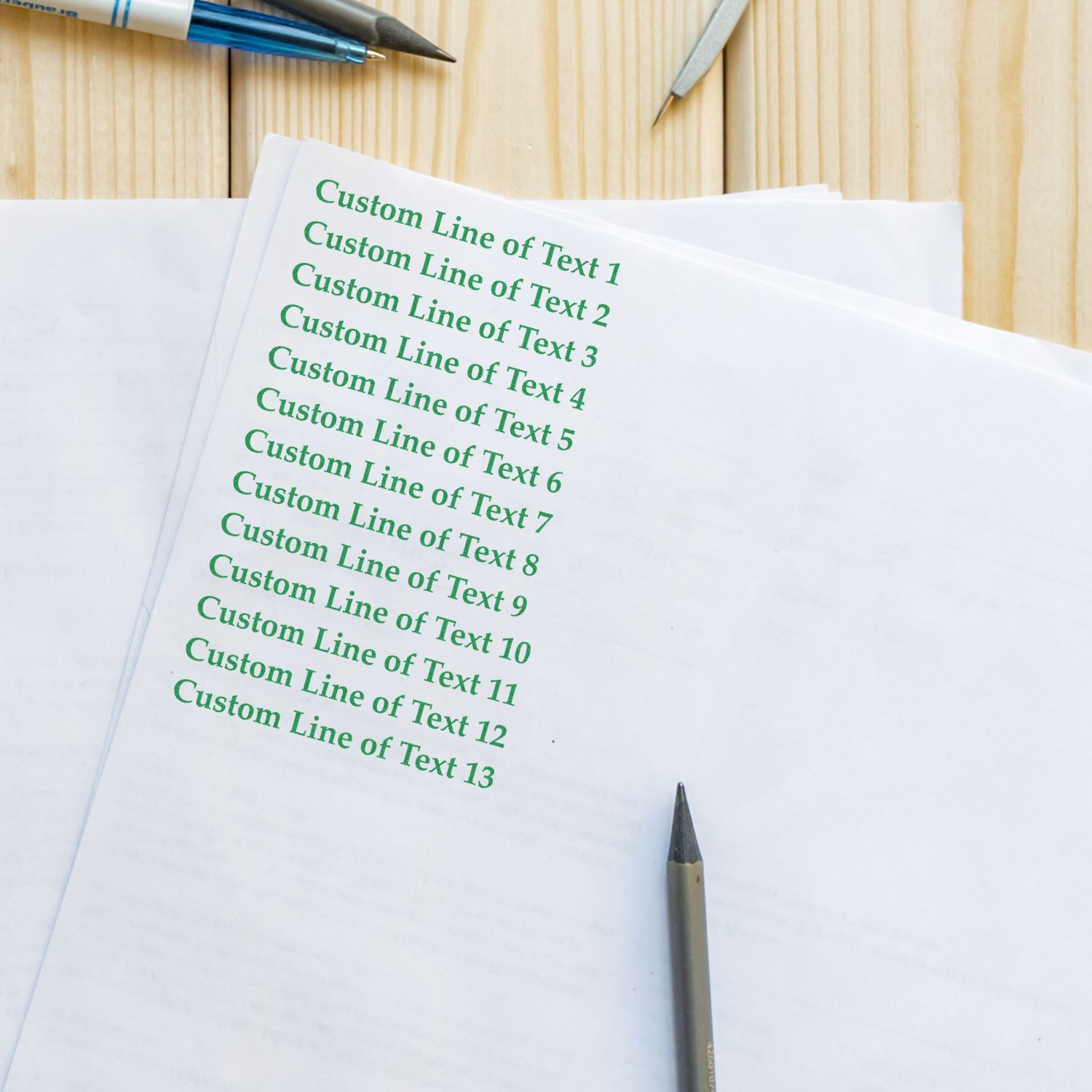 Document mockup showing custom green text lines on white paper with pens, example layout template for printing or graphic design.