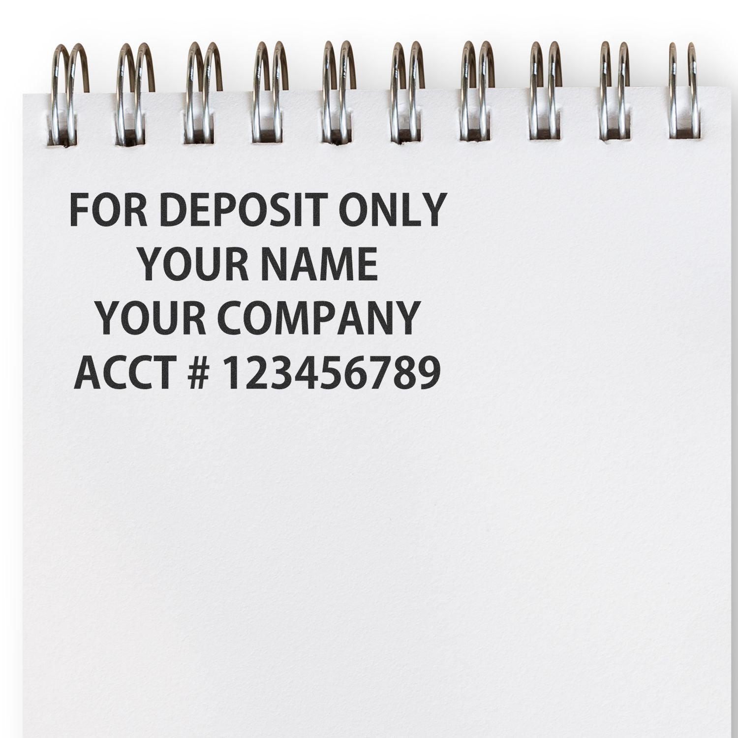 Spiral notebook page with For Deposit Only business check endorsement template, company name, and account number text.
