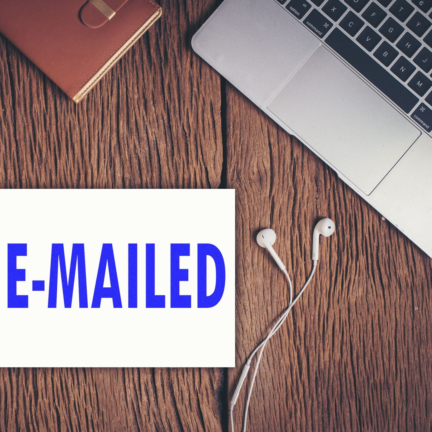 E-MAIL concept with laptop keyboard, wired earbuds and phone accessories on wooden deskillustrates email communication and marketing.