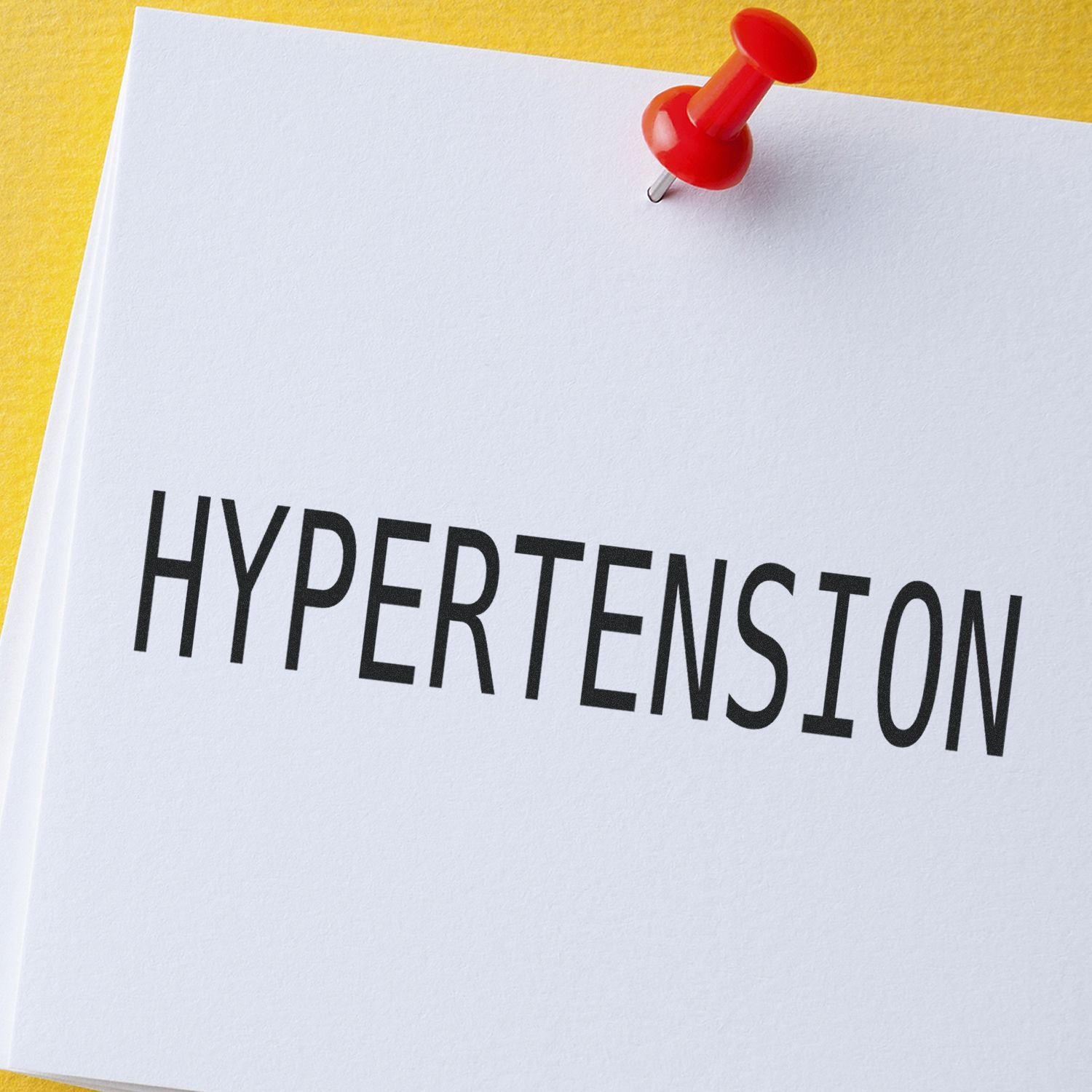 Hypertension awareness: red pushpin marks a medical sheet labeled HYPERTENSION.