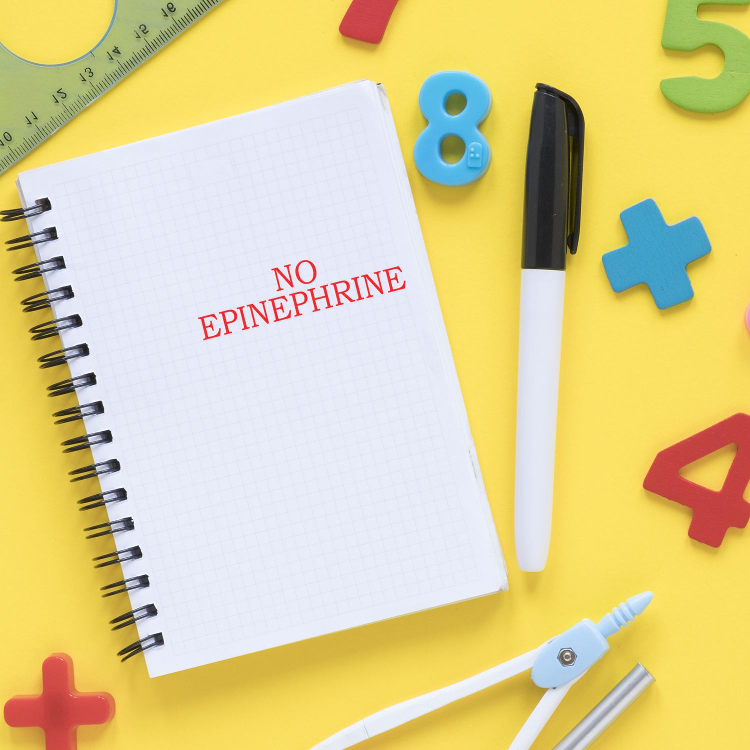 Notebook page reading NO EPINEPHRINE with stationery tools, highlighting a medical warning to avoid epinephrine.