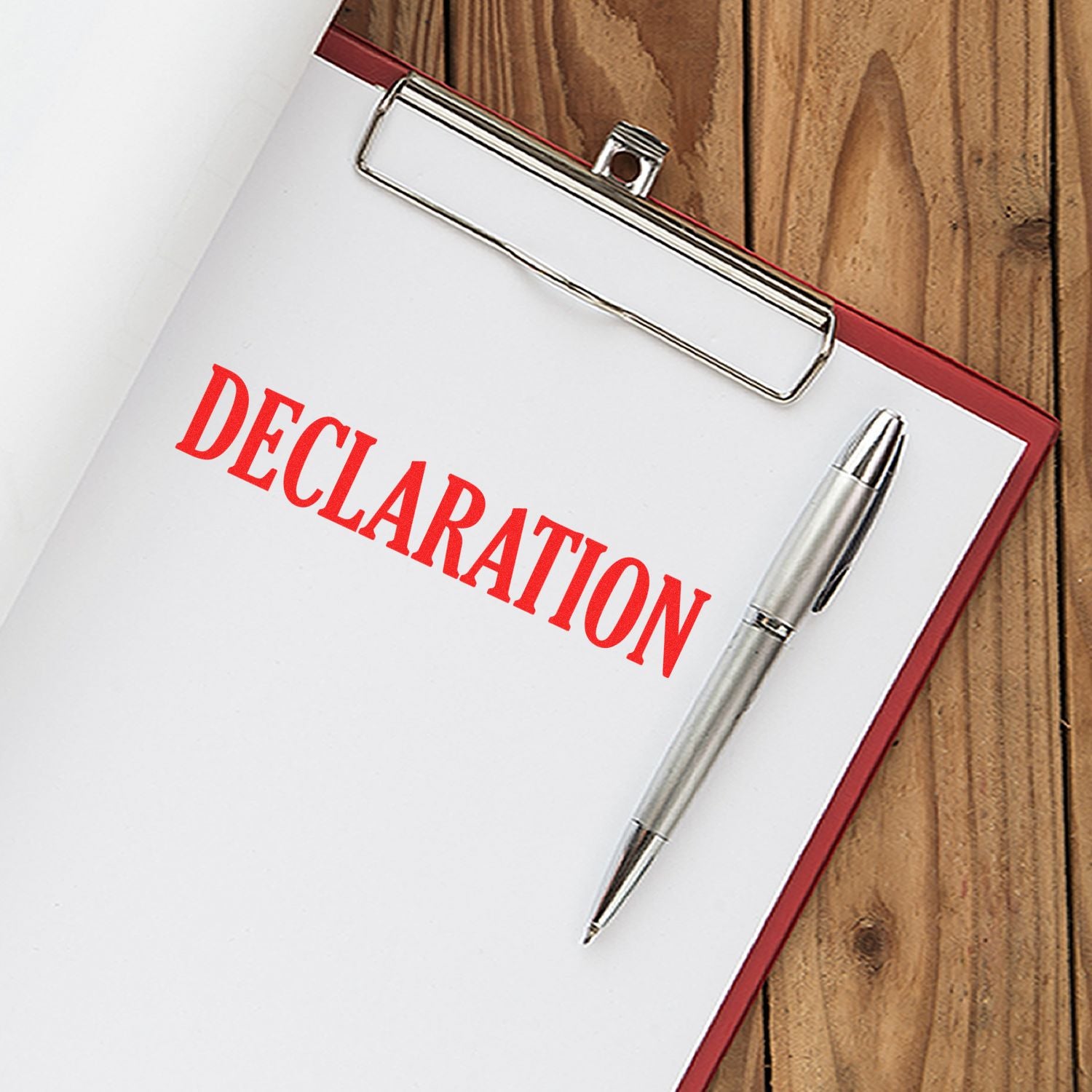 Declaration notebook and pen with metal clip, stationery set for writing and keeping documents organized on kraft background.