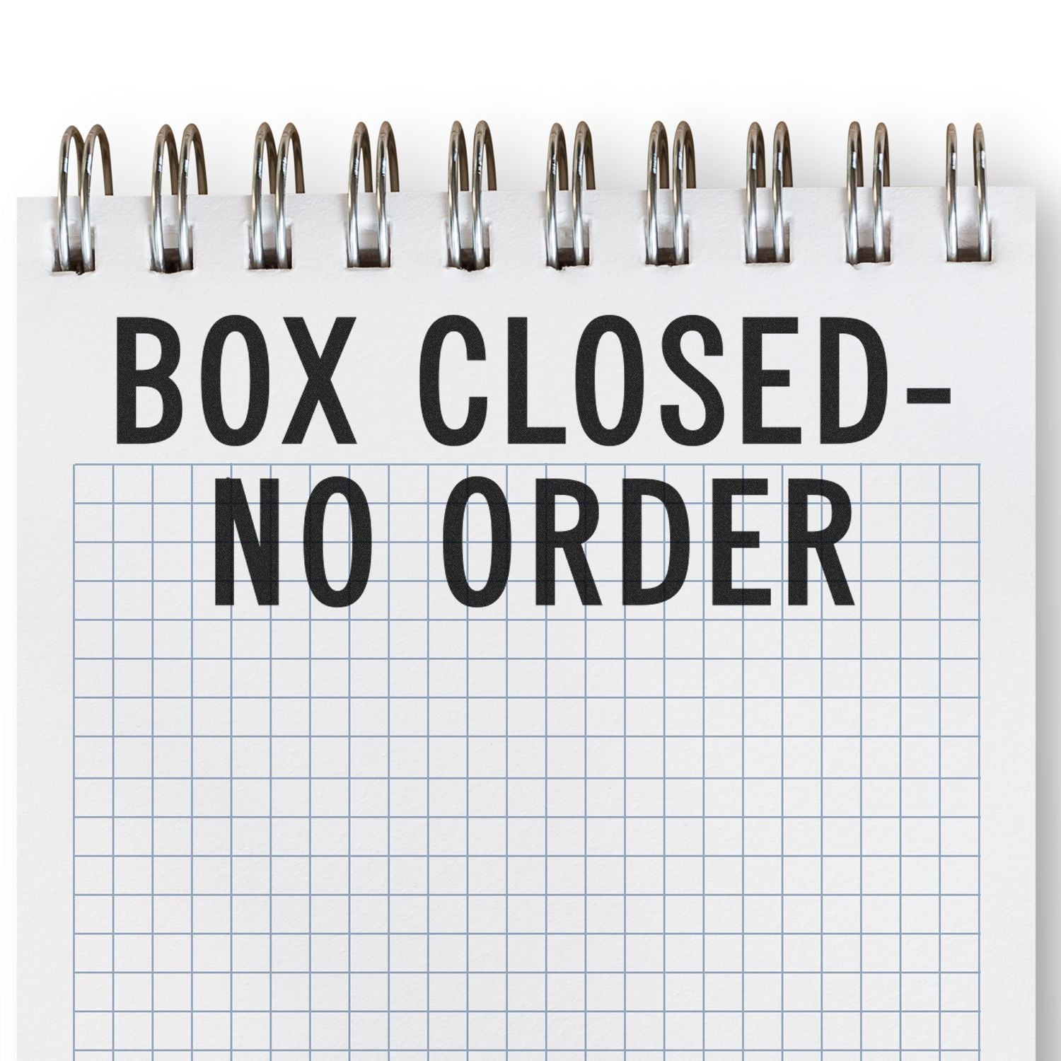 Box ClosedNo Order sign with binder rings on a grid background, indicating a closed box and no orders.