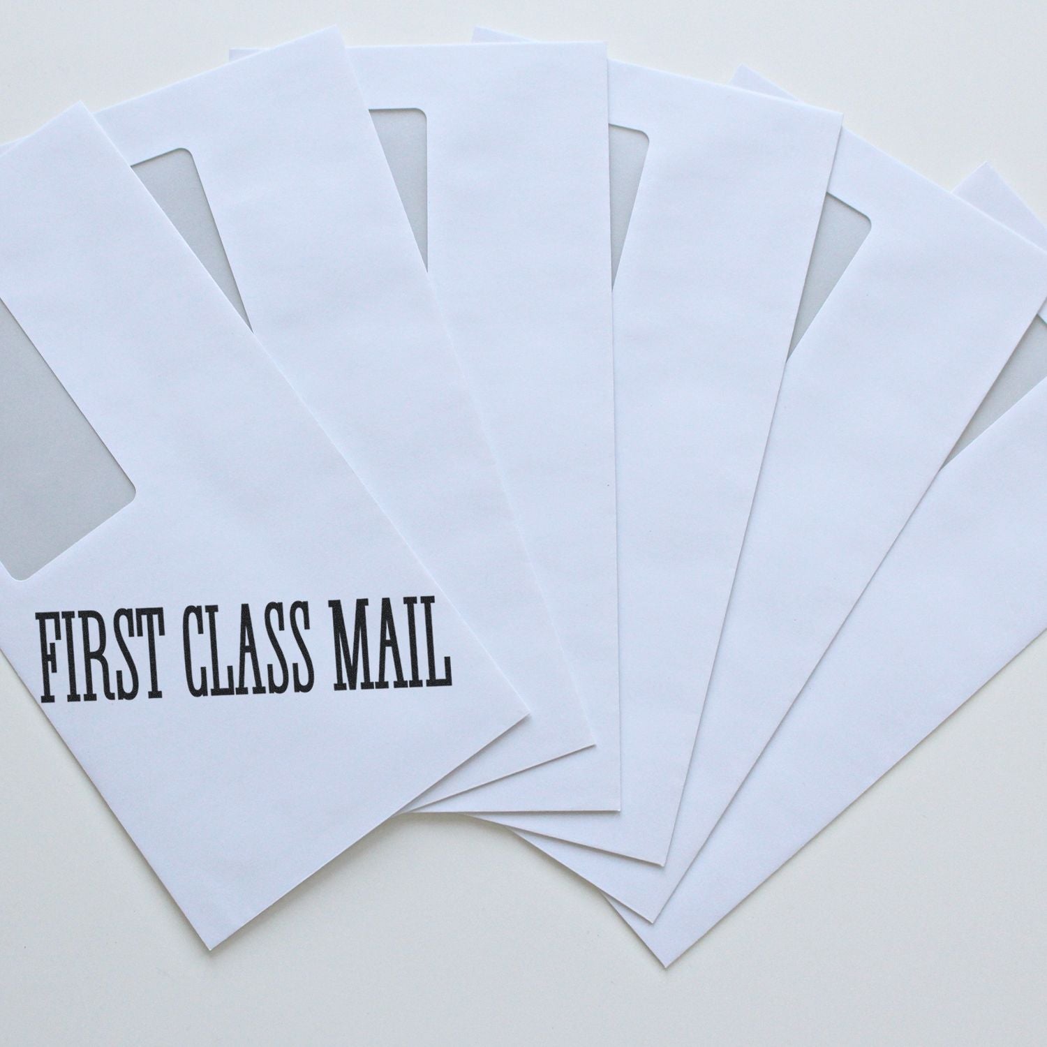 Stack of First Class Mail envelopes for USPS-style fast shipping and delivery marketing, showing first class mail service.