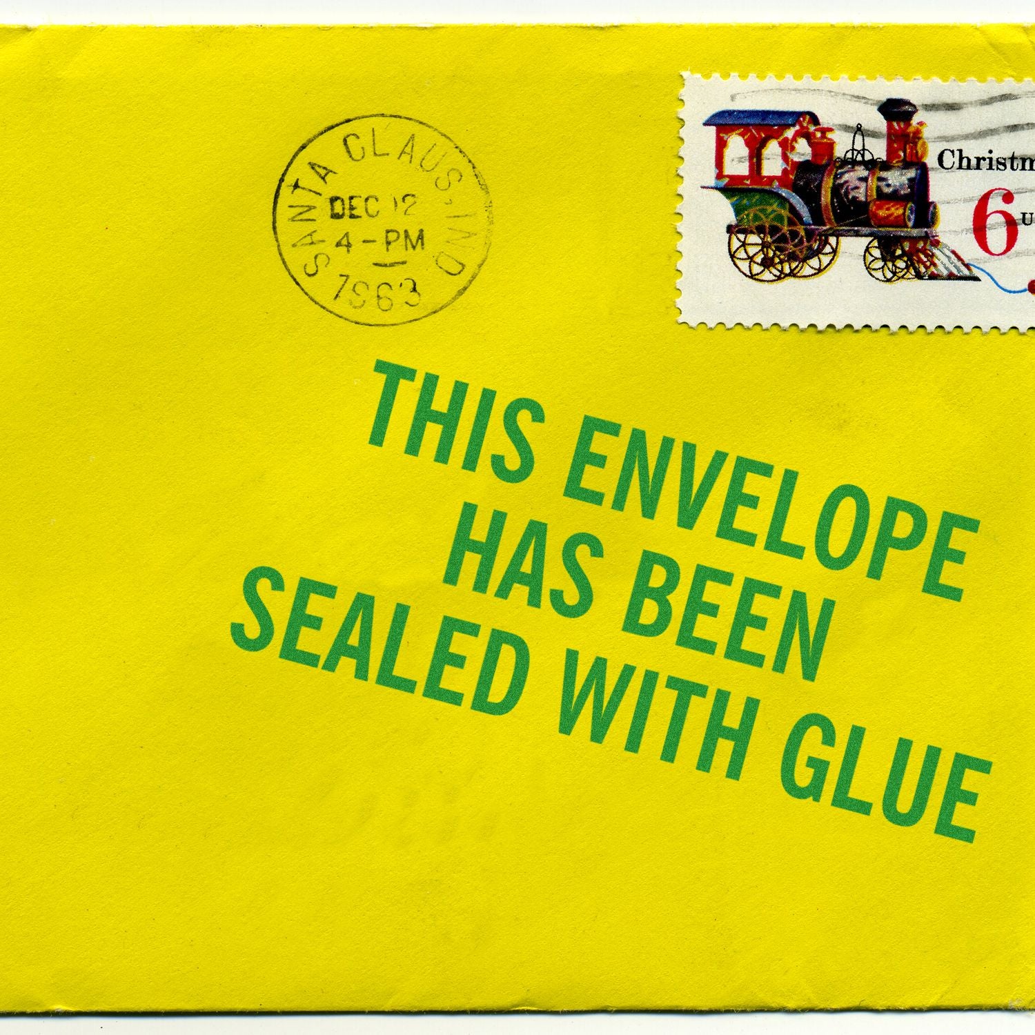 Christmas mailing envelope with Santa Claus postmark, postage stamp, and text: This envelope has been sealed with glue