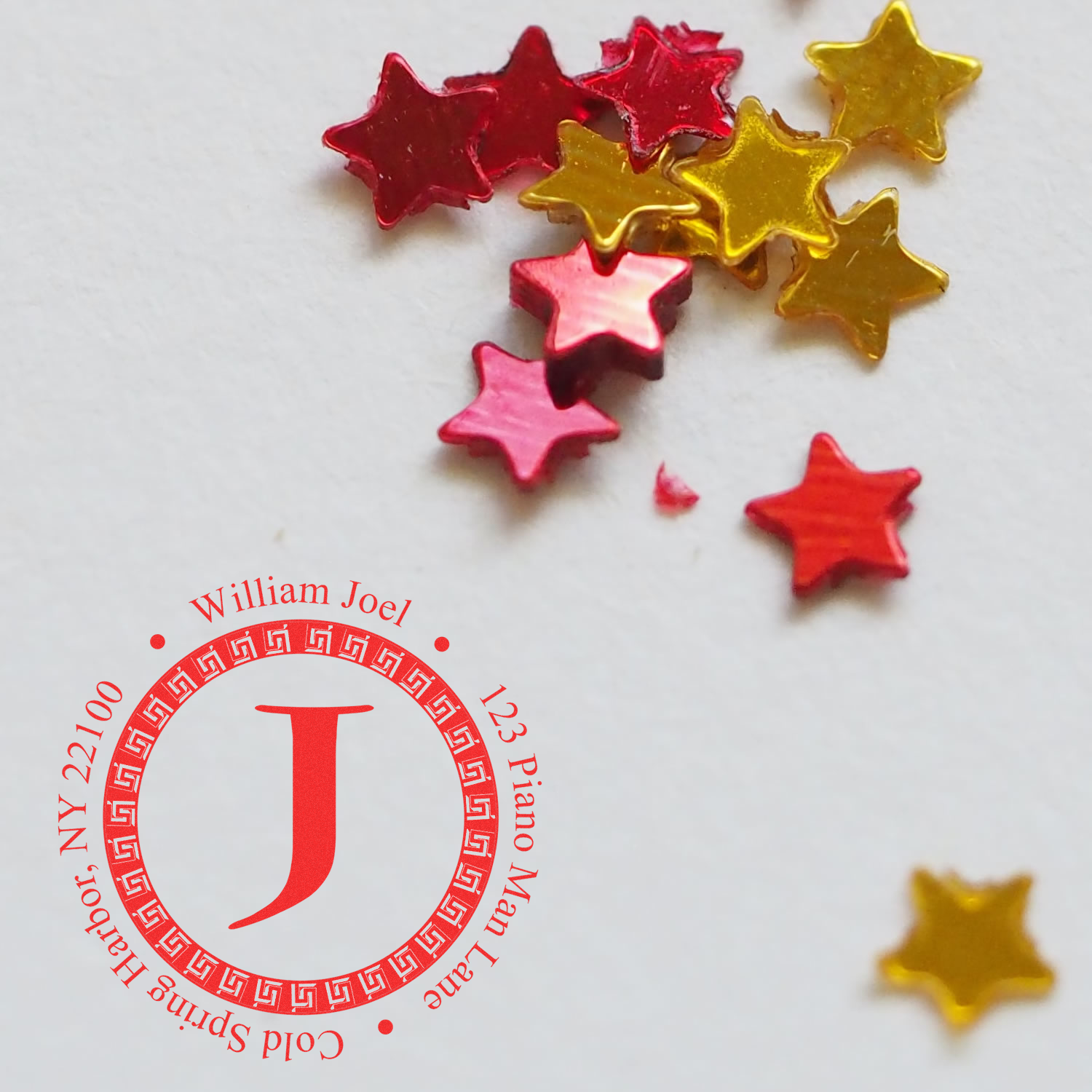 Personalized monogram address rubber stamp with initial J and star confetti for invitations, packaging, and crafts.