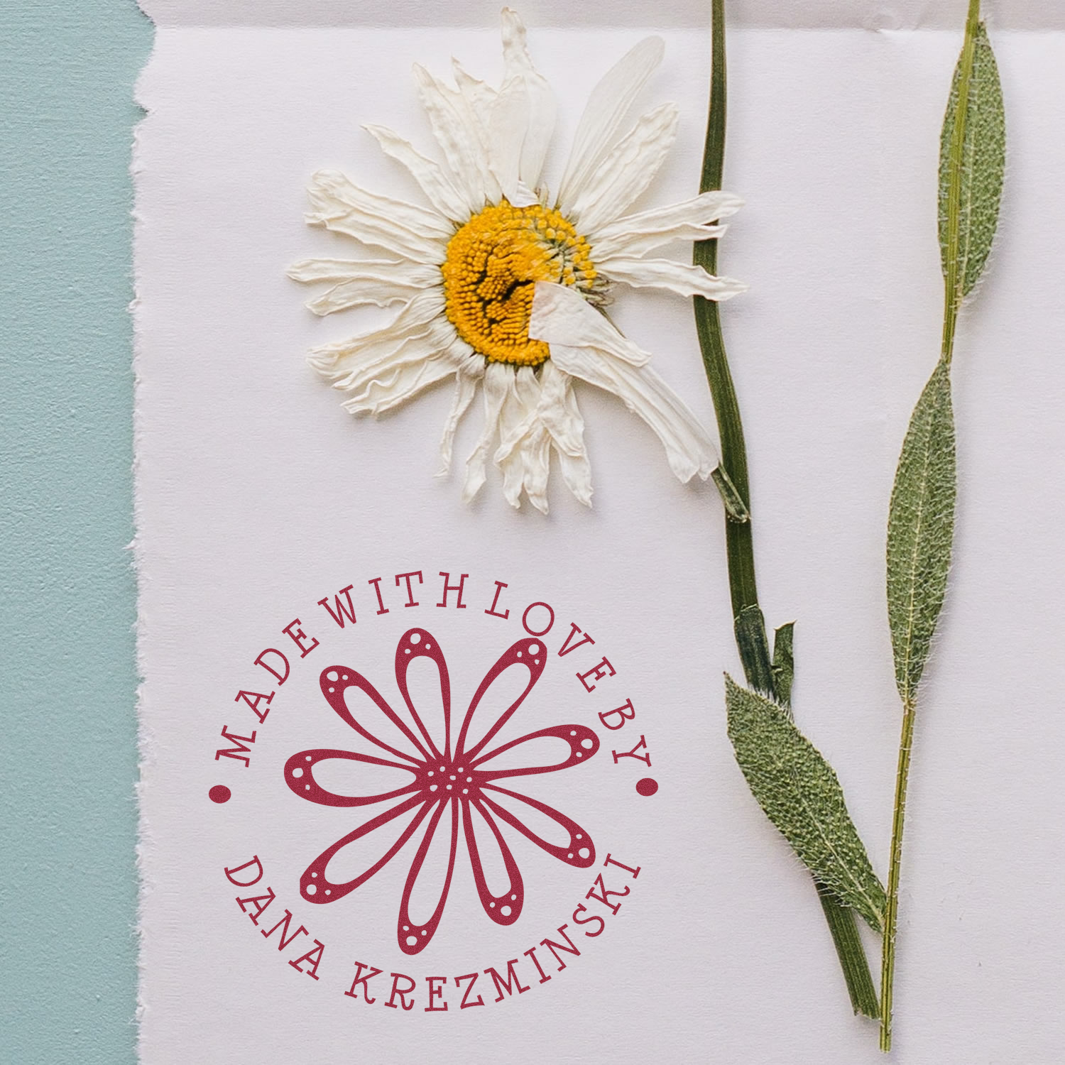 Custom rubber stamp with daisy logo and Made with Love by Dana Krezminski for handmade packaging.