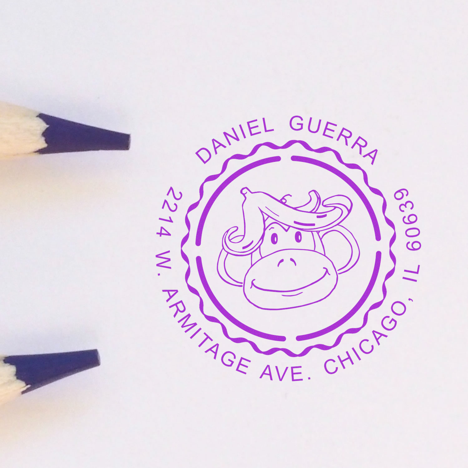 Purple custom rubber stamp proof for Daniel Guerra, 2214 W. Armitage Ave., Chicago, with monkey logo.