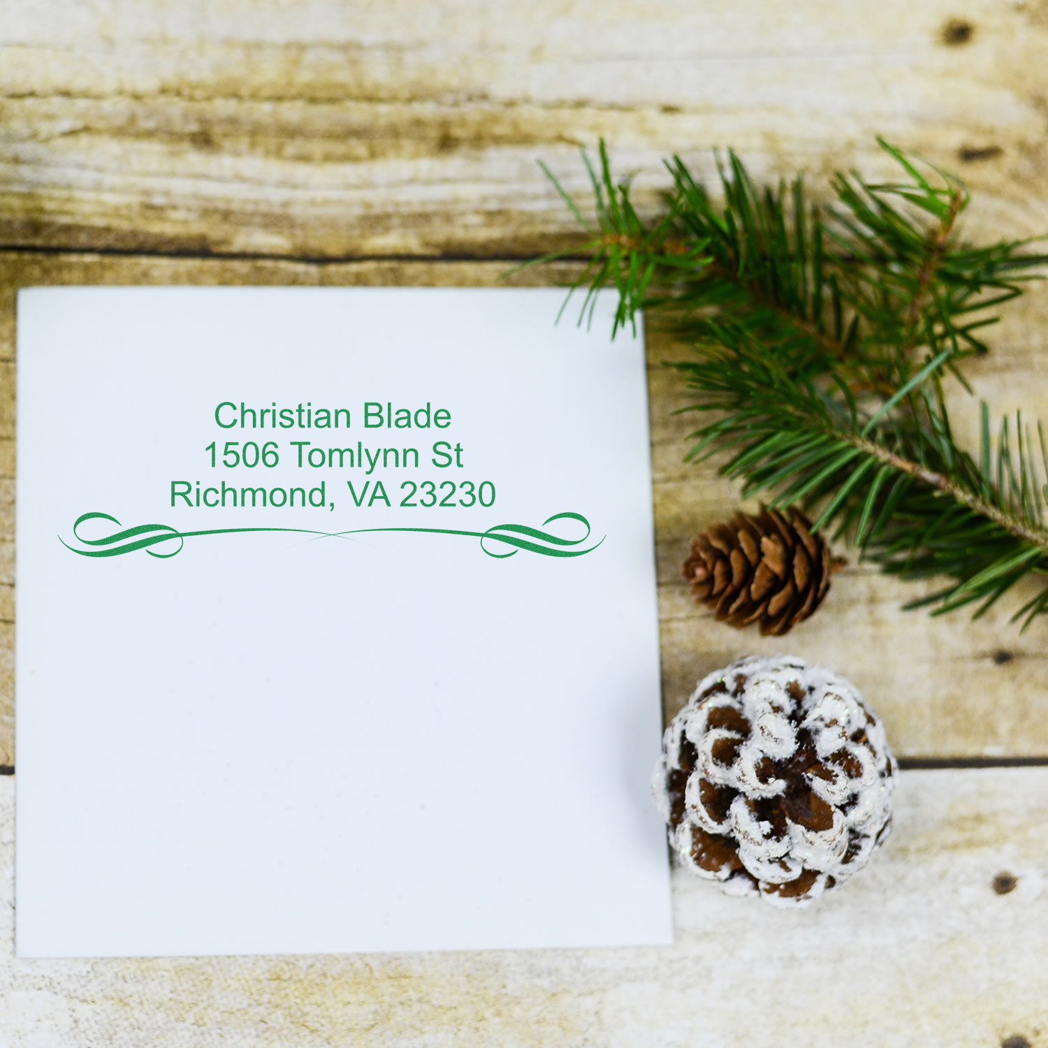 Custom return address rubber stamp on holiday envelope with pinecone decor, featuring Christian Blade, Richmond, VA 23230