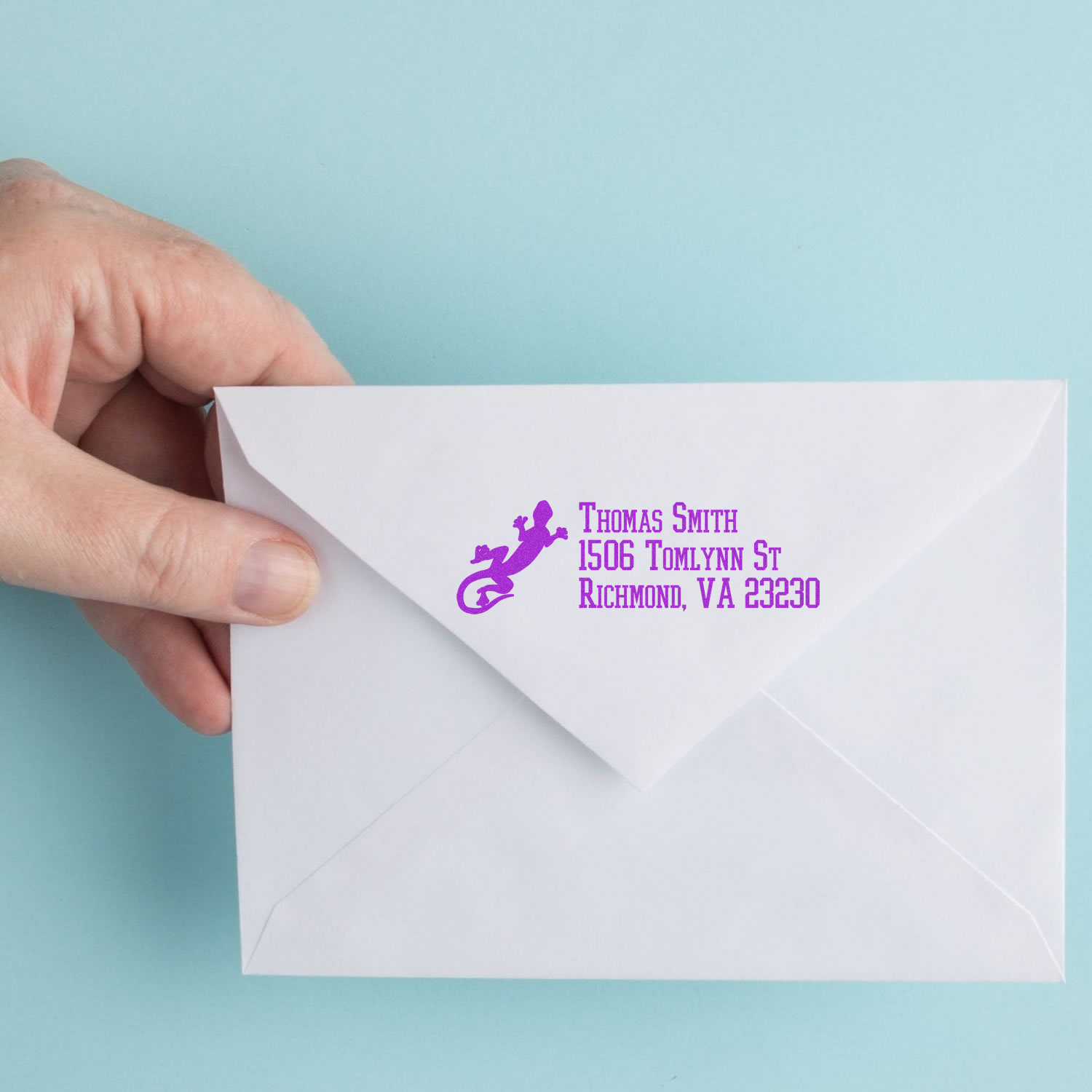 Custom return address rubber stamp in purple on a white envelope, featuring a gecko logo and Thomas Smith address.