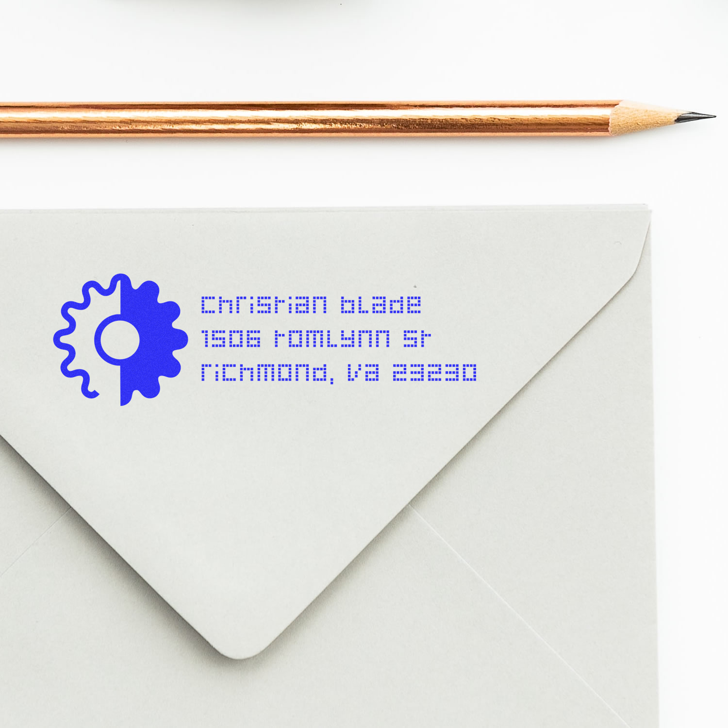 Personalized return address rubber stamp on envelope with blue logo, ideal for custom mailing and stationery.