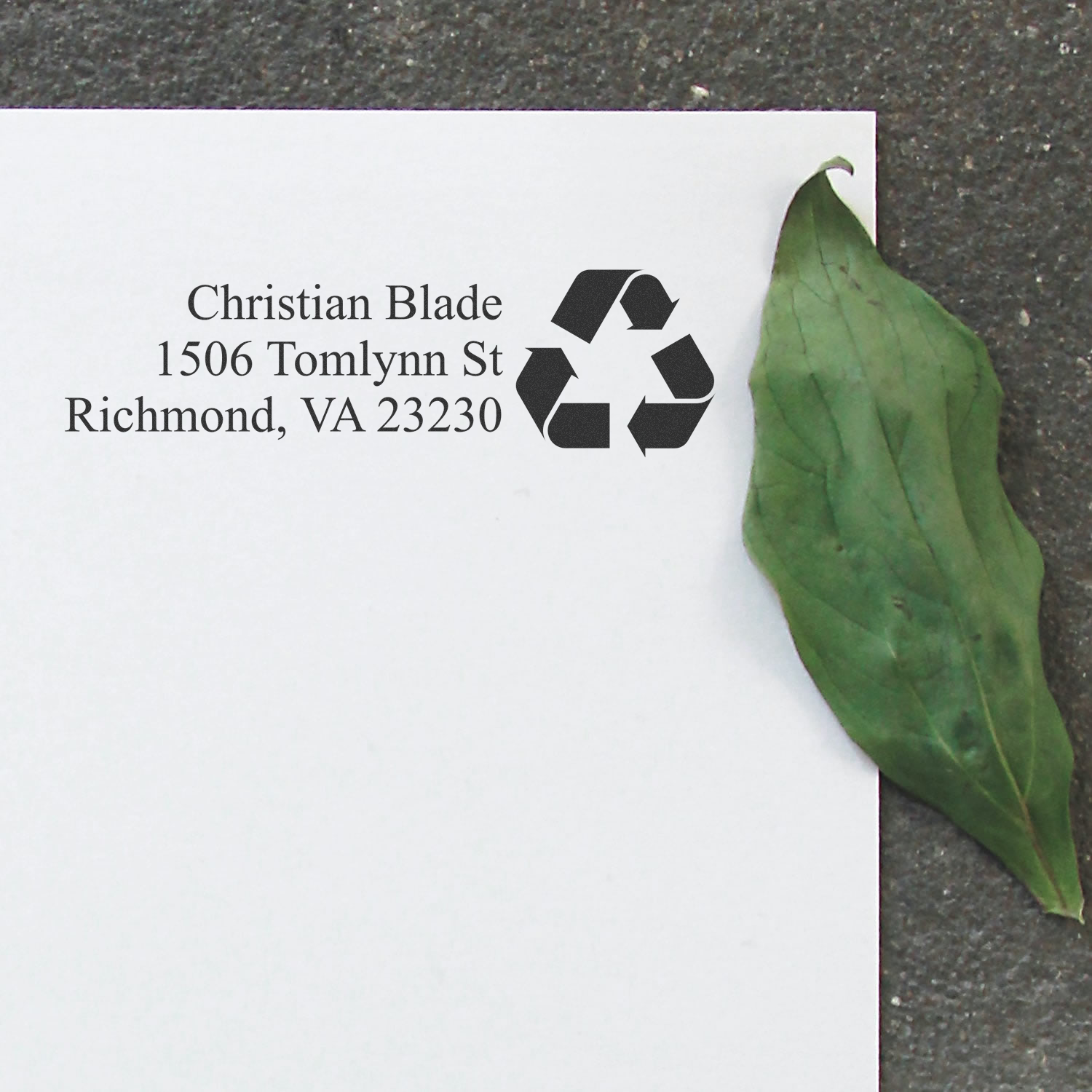 Custom return address rubber stamp with recycling symbol on white envelope, for eco-friendly mailing in Richmond, VA.