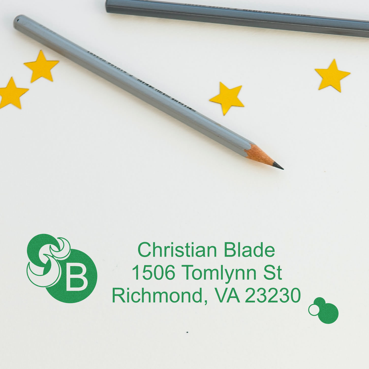 Custom rubber stamp impression with Christian Blade logo, address, and green ink on paper, shown beside a pencil and star accents.