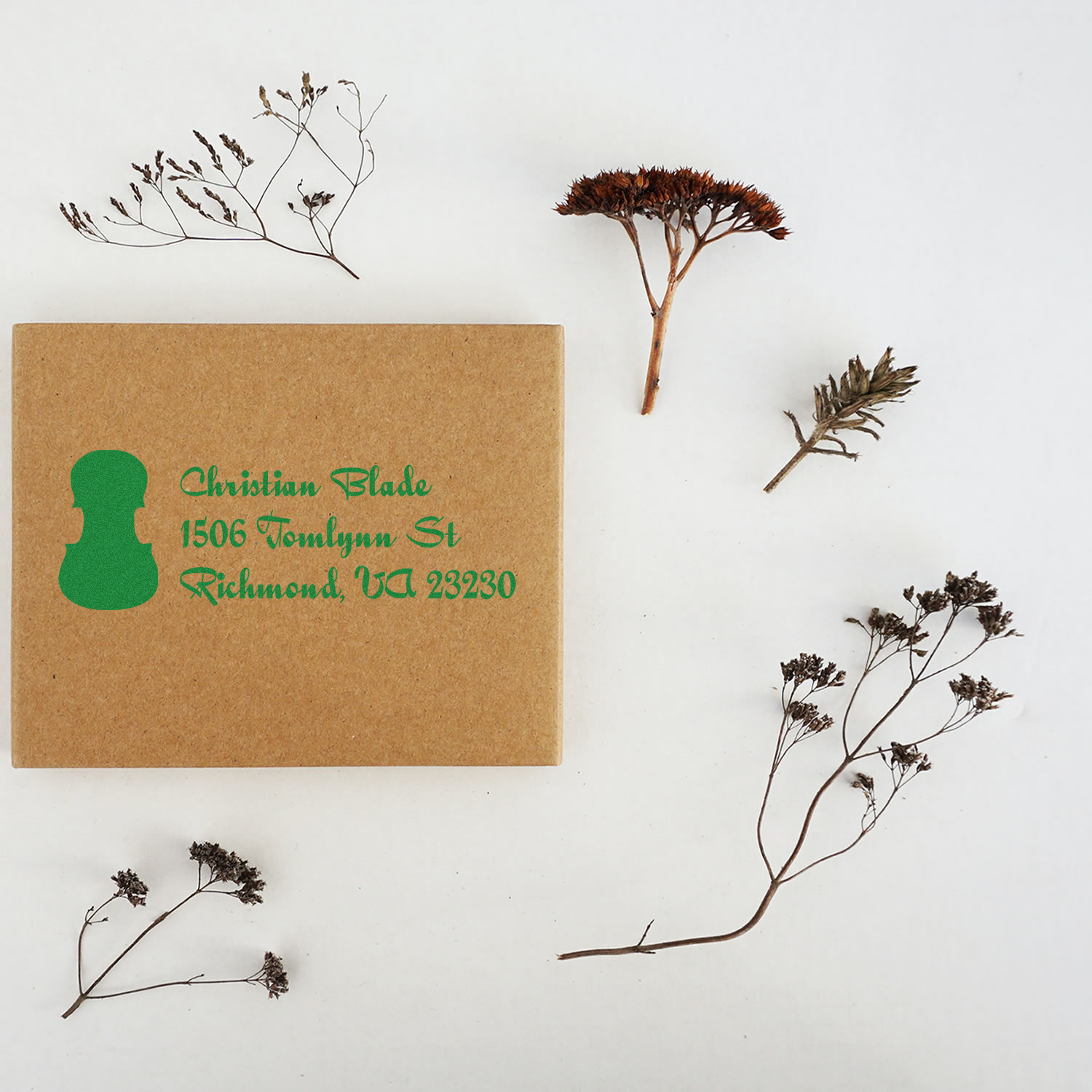 Custom address rubber stamp on kraft box, showing green return address imprint for packaging and branding.