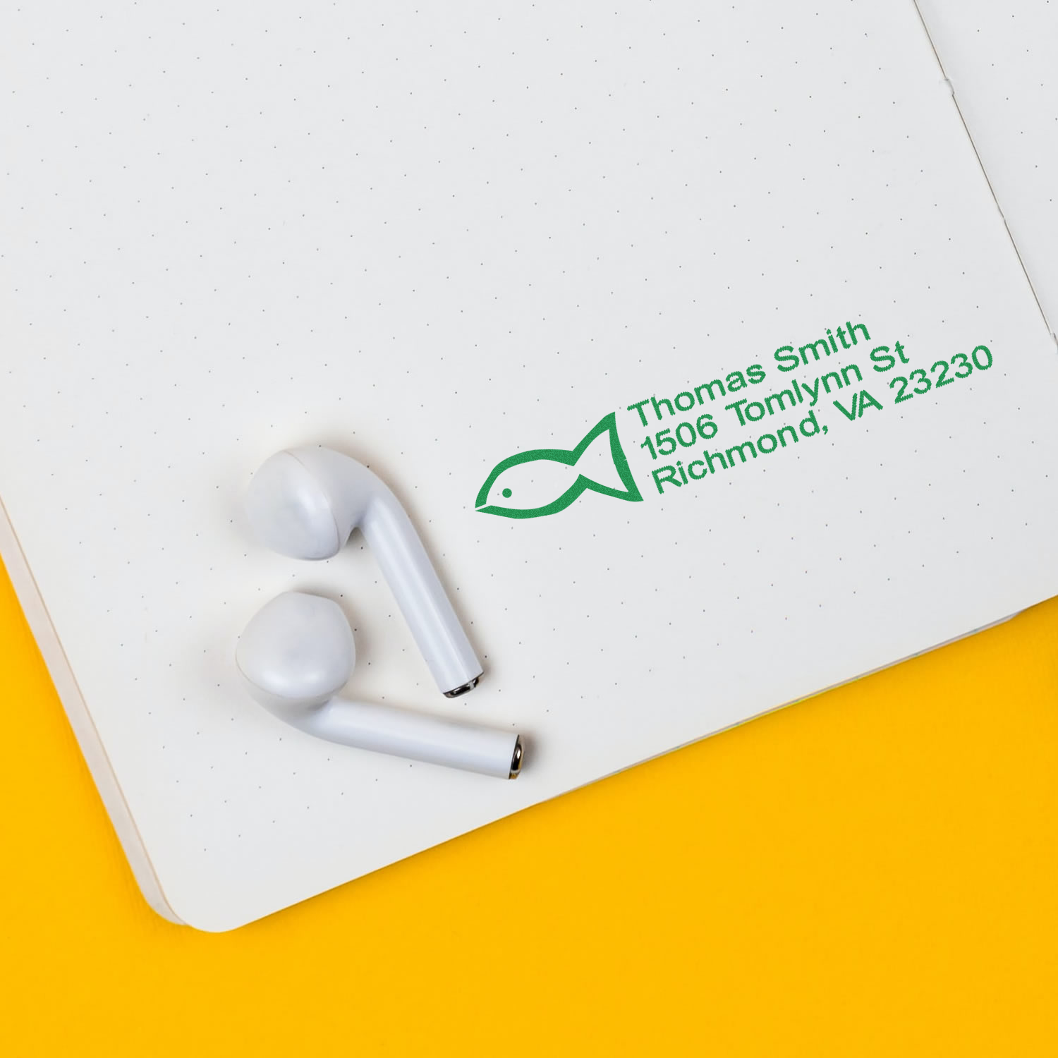 Custom return address rubber stamp impression with fish logo and Richmond, VA address on a notebook.