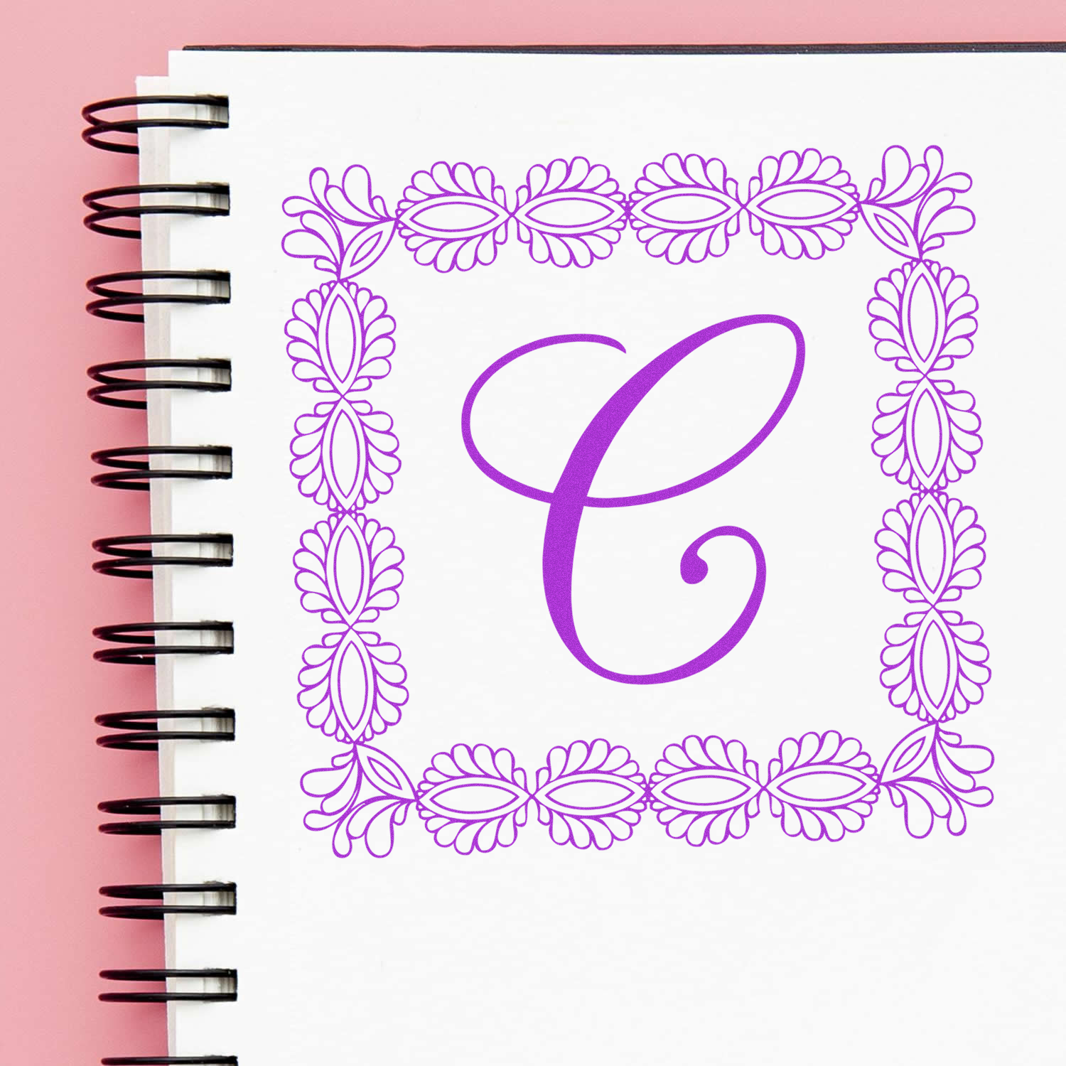 Floral monogram C rubber stamp design for personalized stationery on a spiral notebook.
