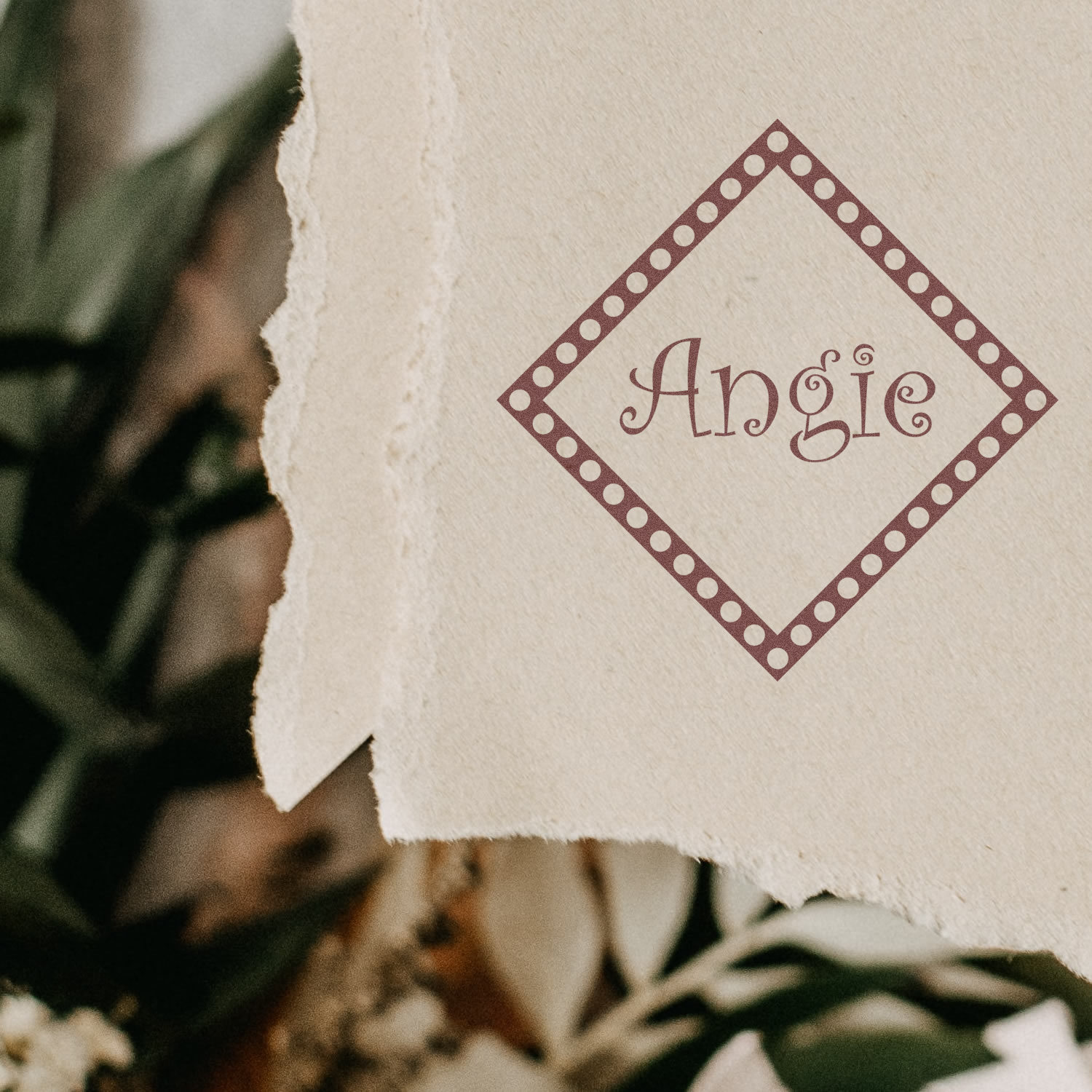 Personalized Angie rubber stamp impression with decorative diamond border on textured paper