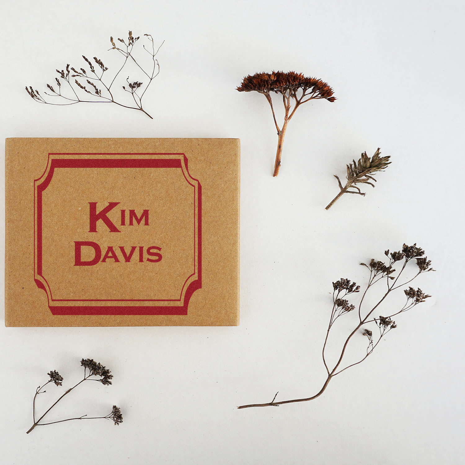 Custom name rubber stamp for kraft gift boxes, featuring Kim Davis in a decorative border with dried floral styling.