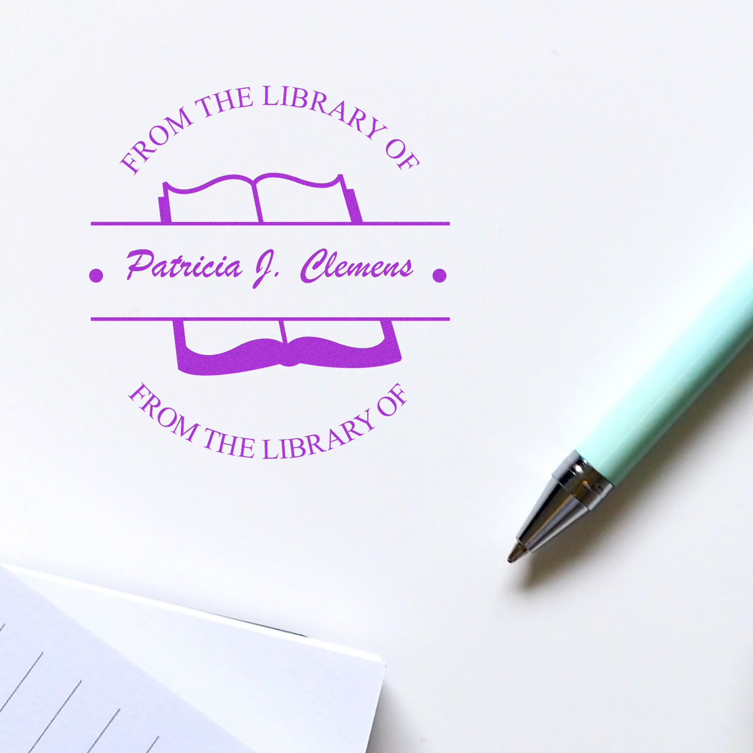 Custom library rubber stamp with open book design and Patricia J. Clemens name for personal book labeling.
