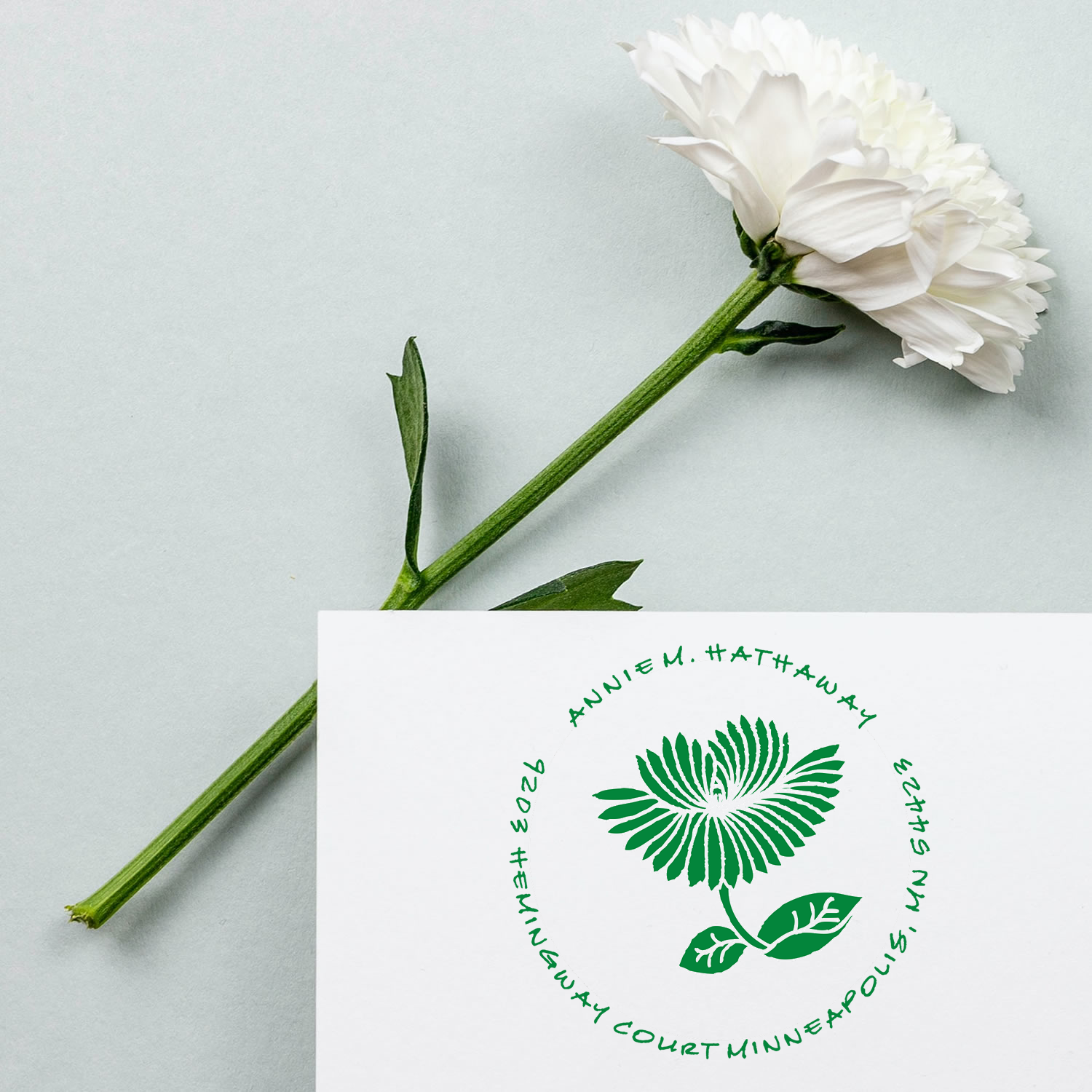 White flower bouquet on light background with green botanical logo card, wellness and mindfulness brand promotion.