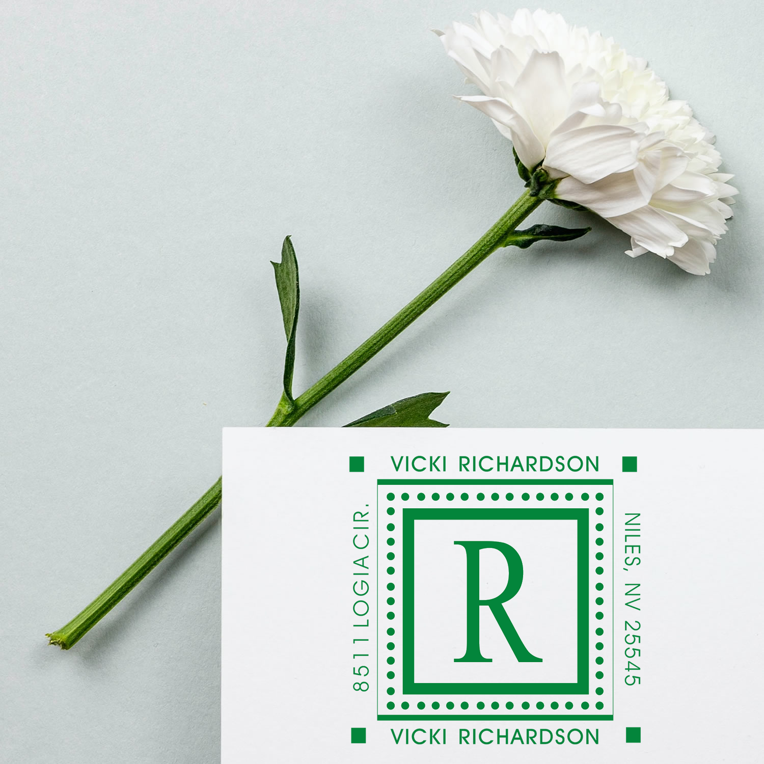 Custom floral monogram rubber stamp with R initial, name, and address for personalized wedding stationery and envelopes.