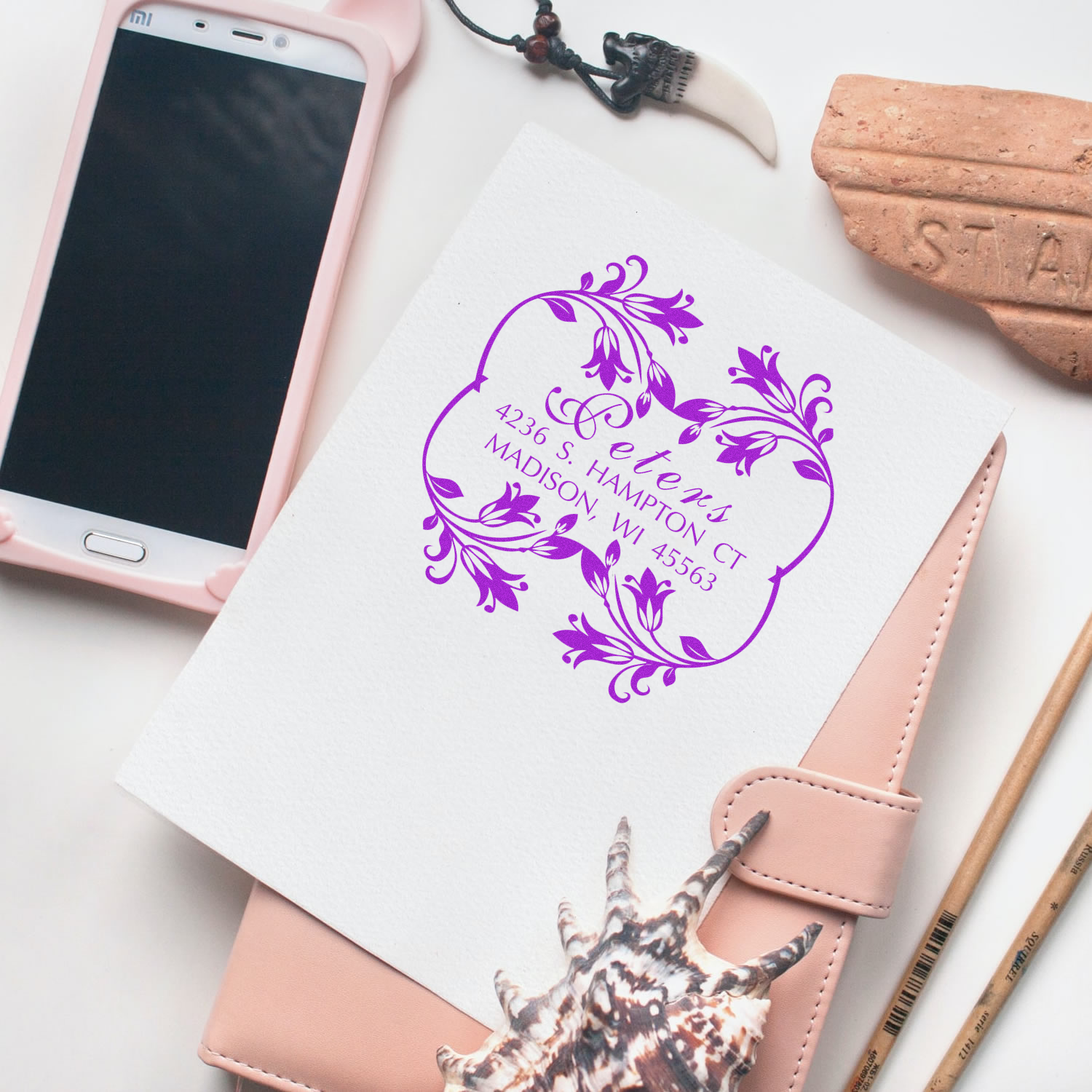 Custom Madison Way address logo on white stationery beside smartphone and wallet, featuring purple ornamental mail label design.
