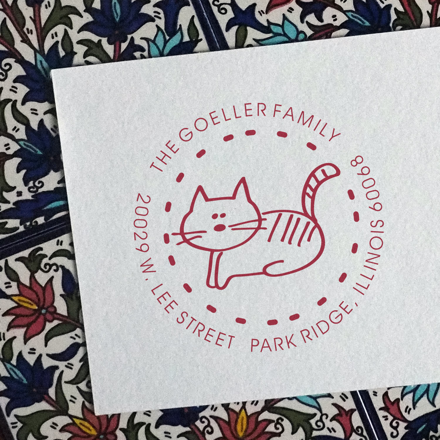 Custom family rubber stamp with cat design and circular name text for personalized stationery.