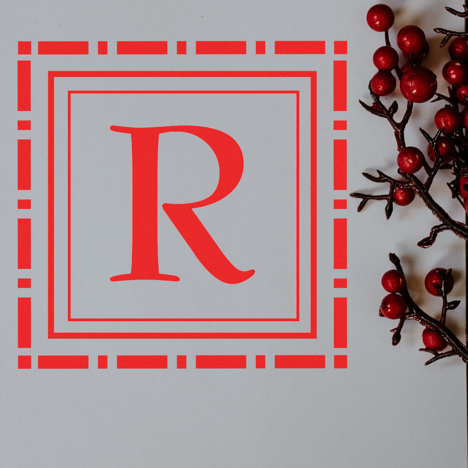 Red monogram R rubber stamp design with decorative border, ideal for personalized stationery, packaging, and holiday cards.