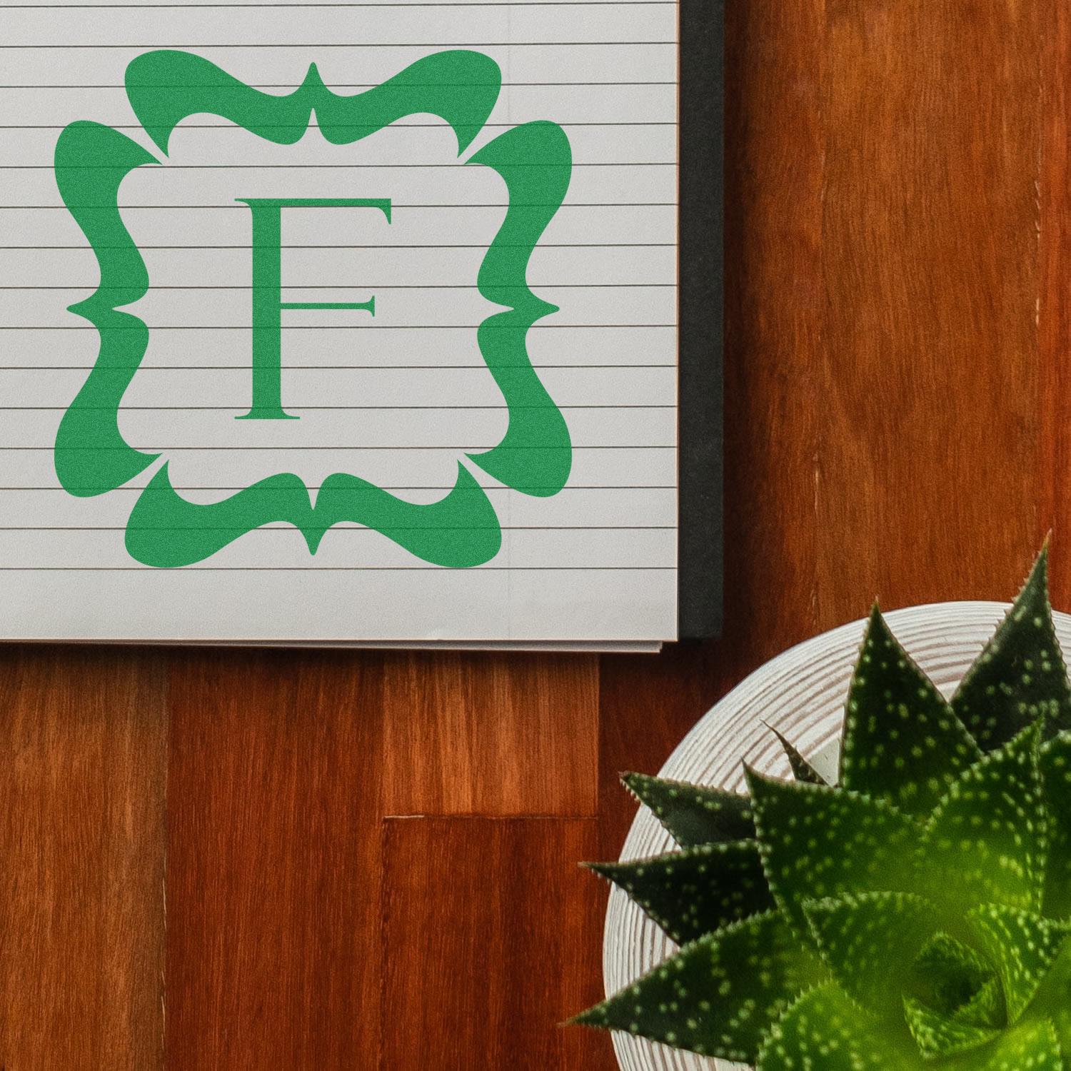 Custom rubber stamp design featuring decorative green monogram letter F for personalized stationery and branding.