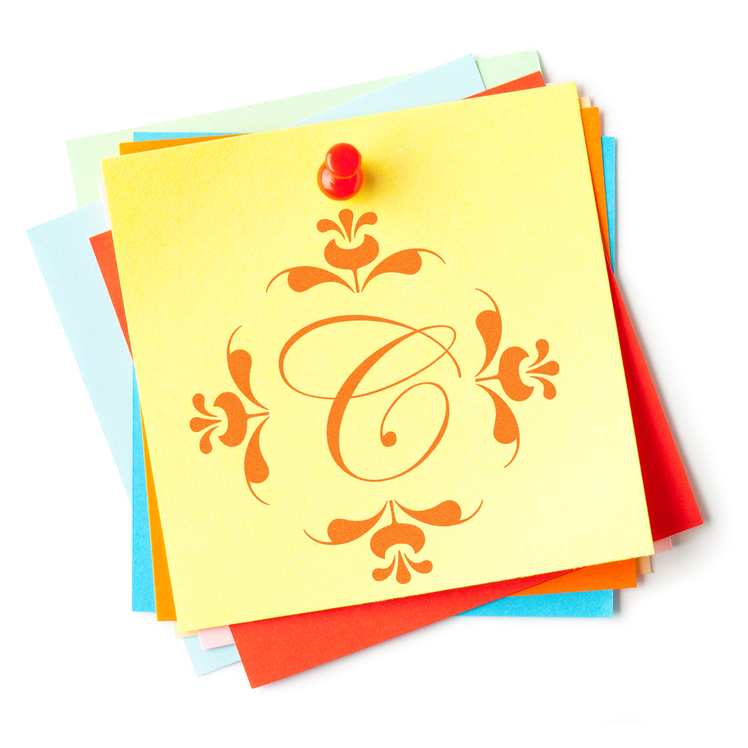 Decorative letter C rubber stamp on stacked colorful sticky notes with red pushpin