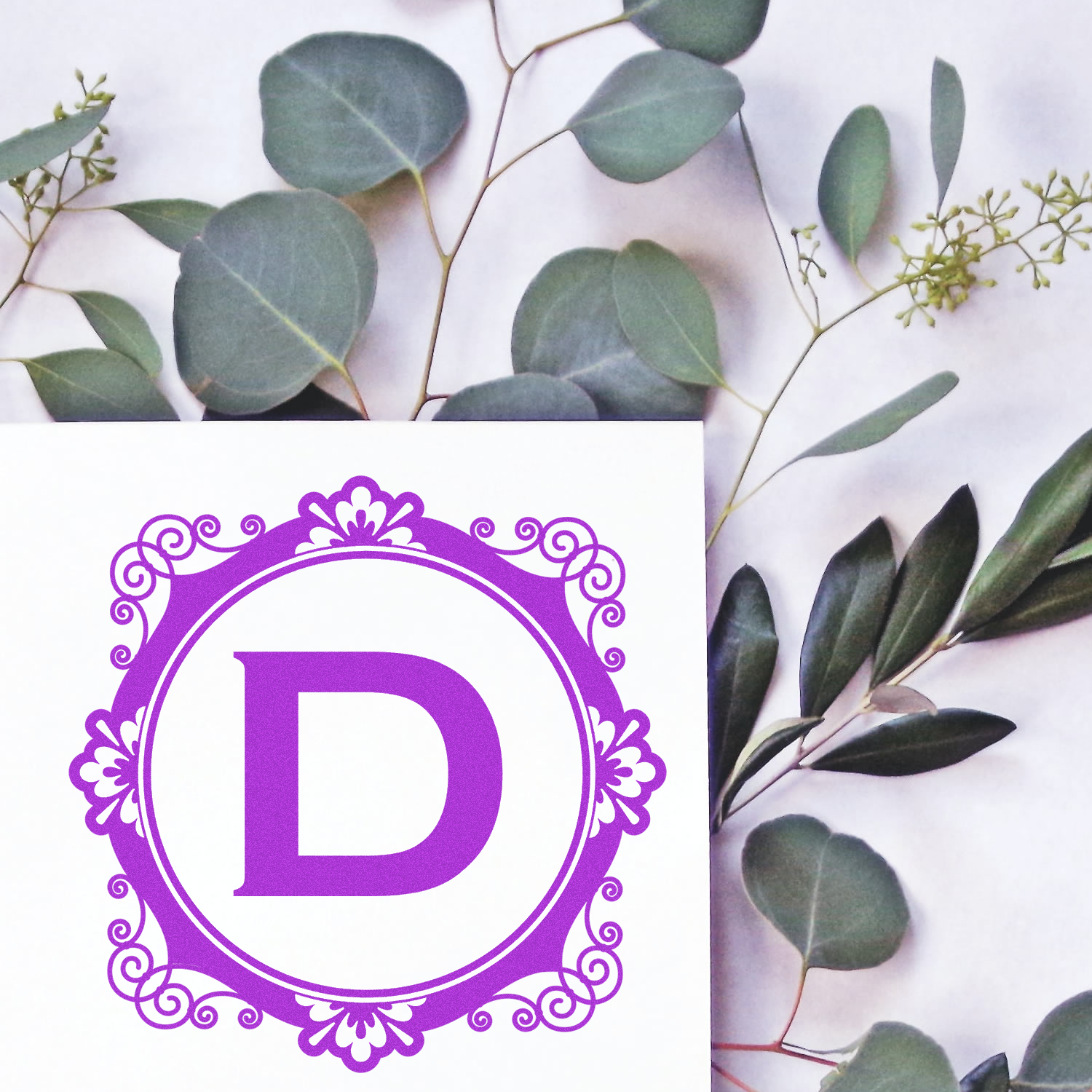 Ornate purple letter D monogram custom rubber stamp design with floral border for stationery and branding